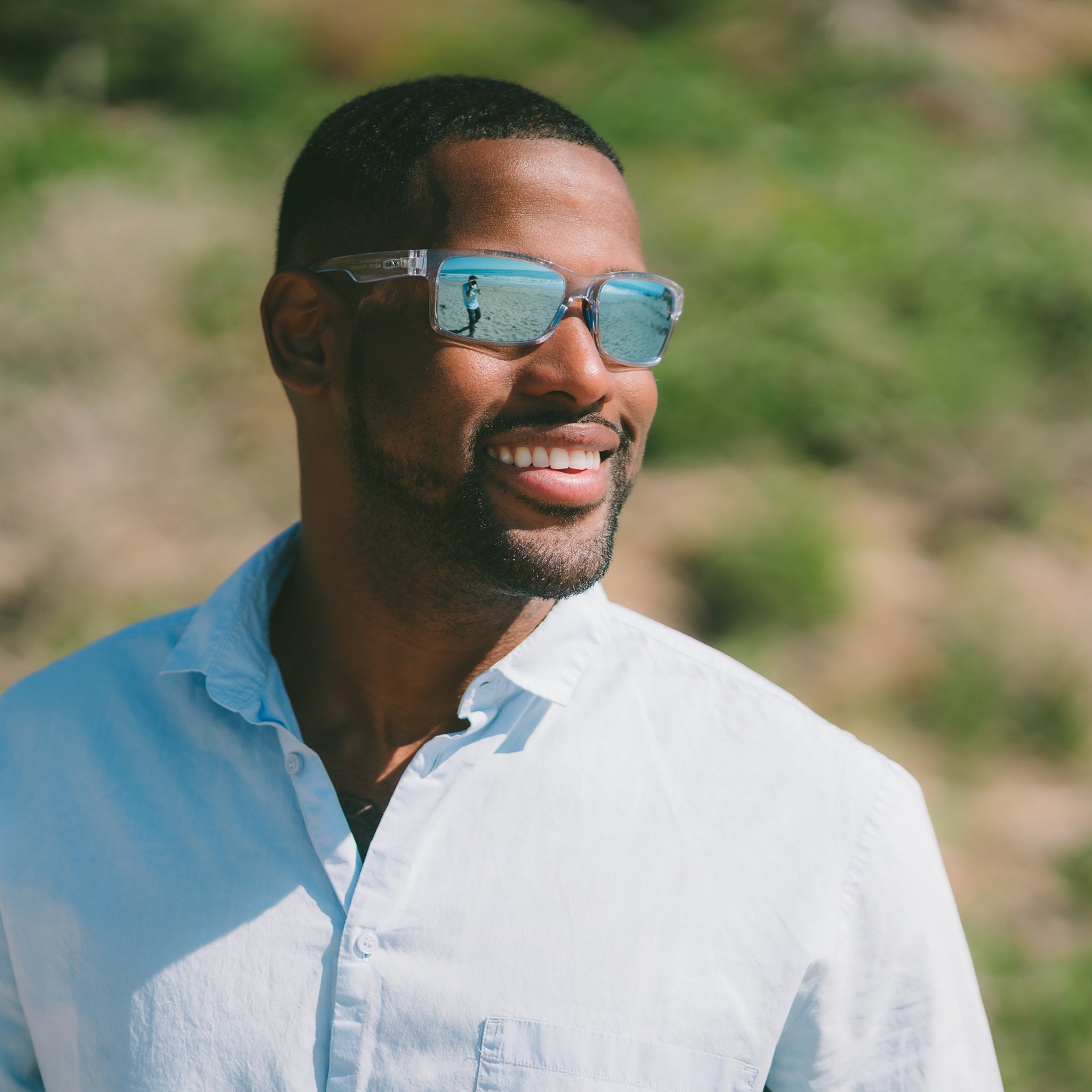Man wearing sunglasses and white shirt in outdoor setting