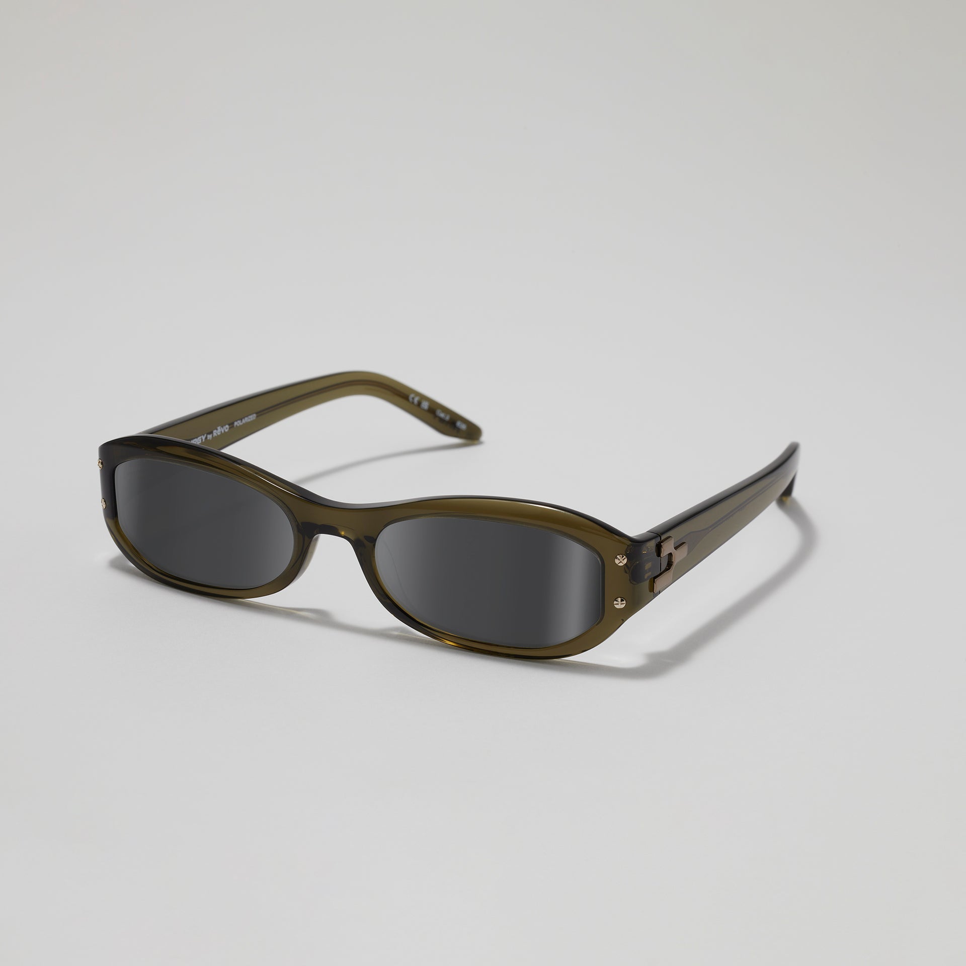 Sunglasses with dark lenses and green frame on a light gray background