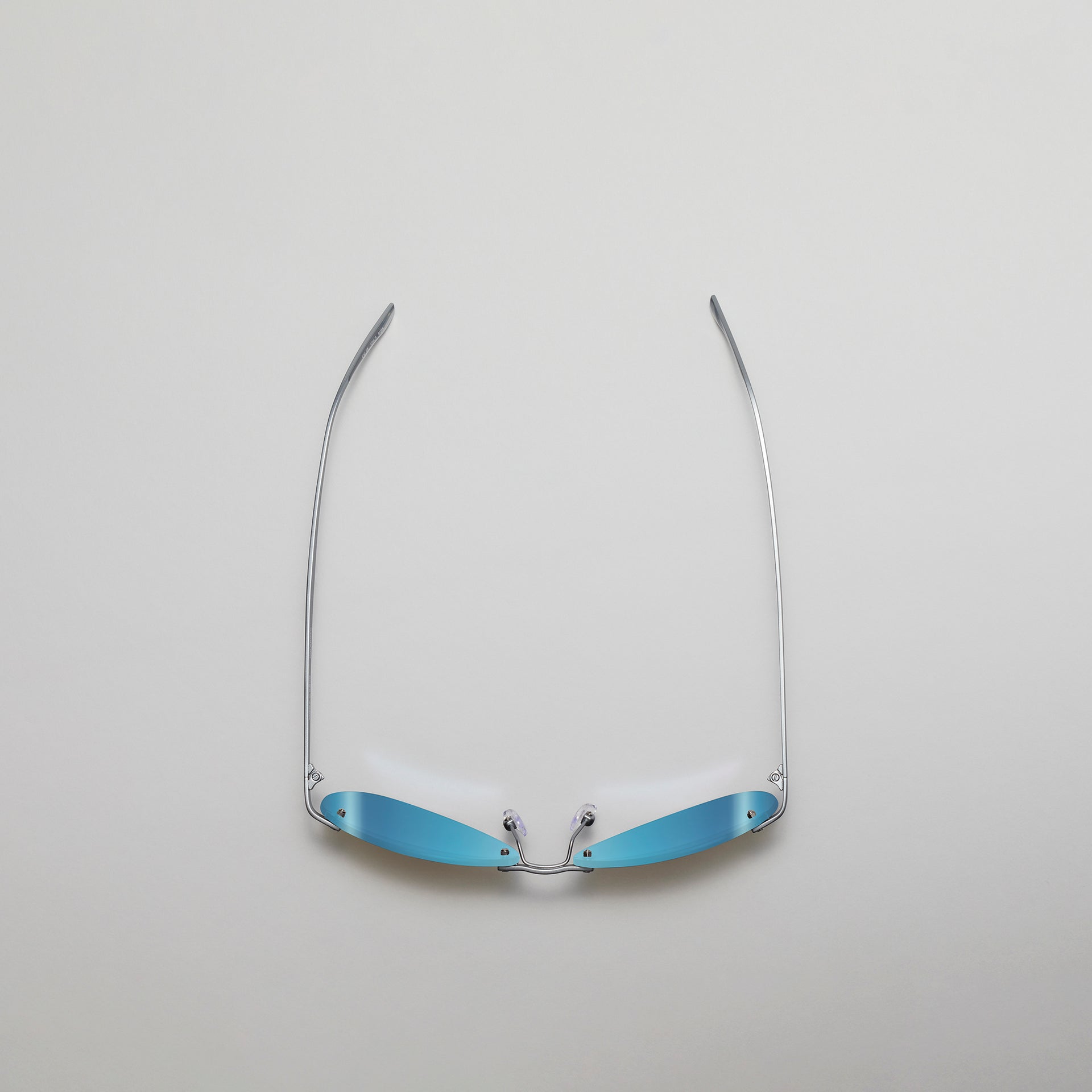 Sunglasses with blue reflective lenses on a light gray background