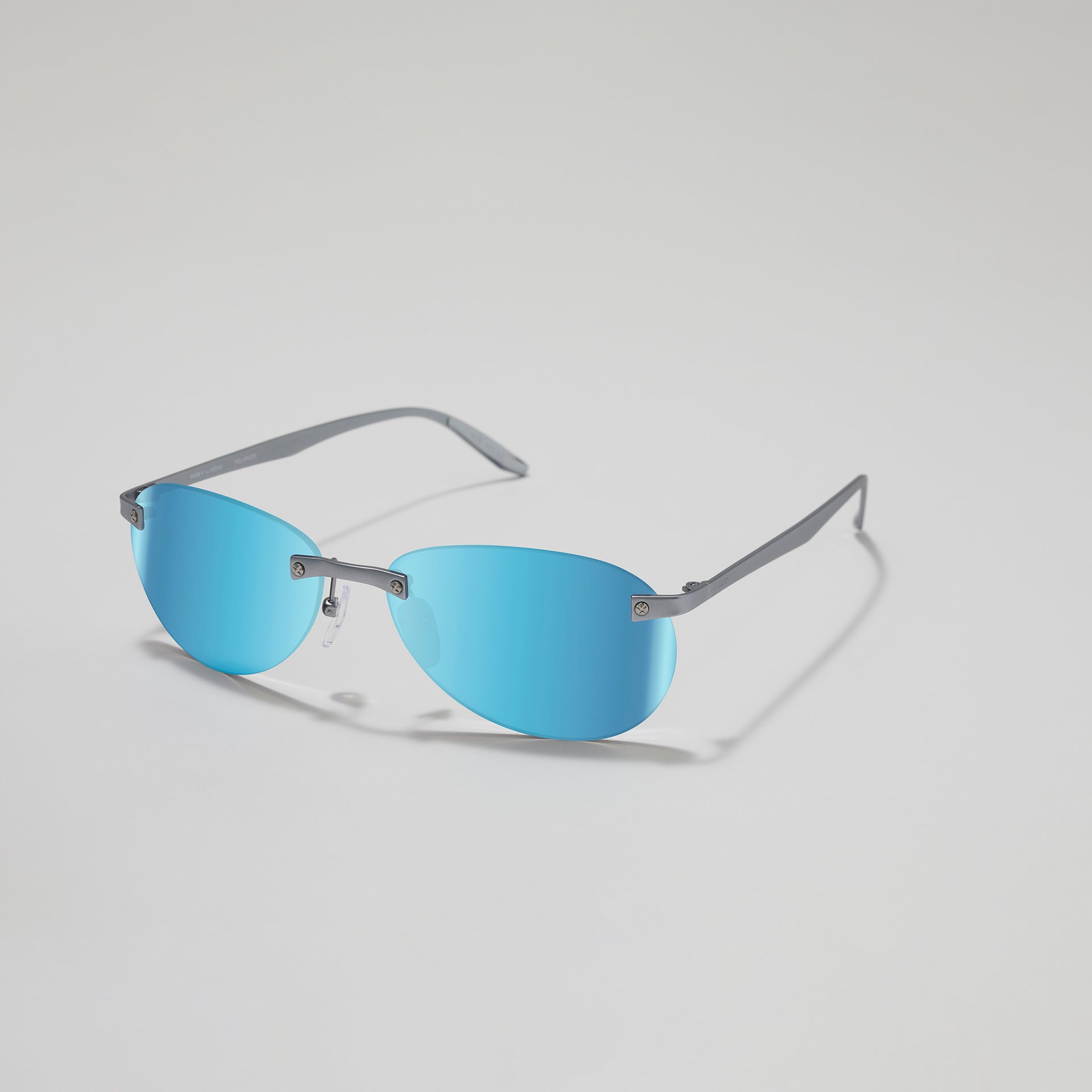 Sunglasses with blue lenses and thin metal frame on a light gray background