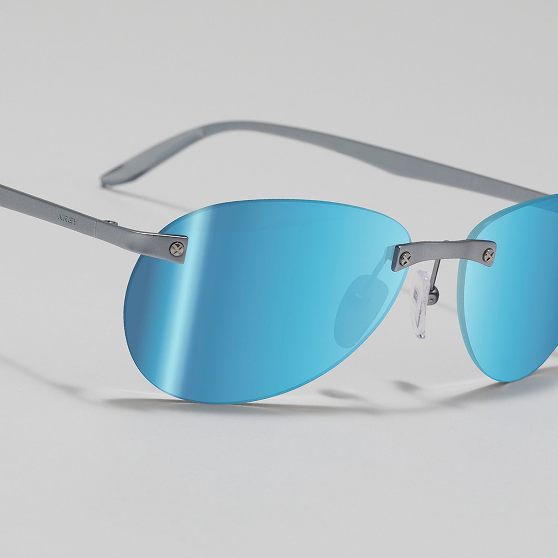 Sunglasses with blue lenses and thin metal frame on a light gray background