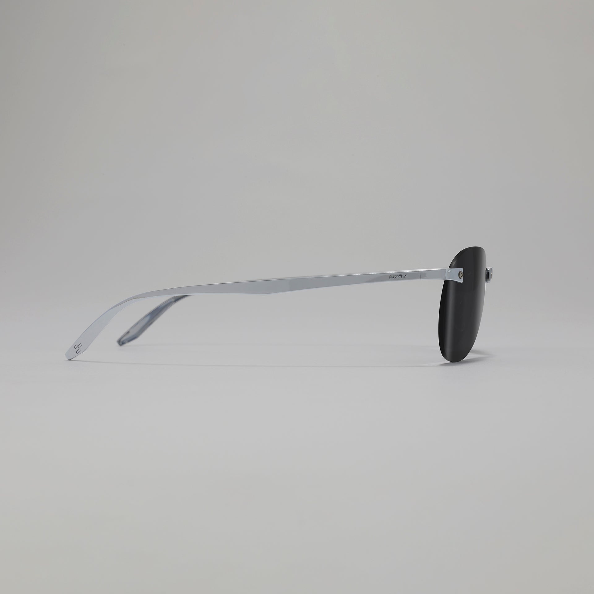 Sunglasses with black lenses and silver frame on a light gray background