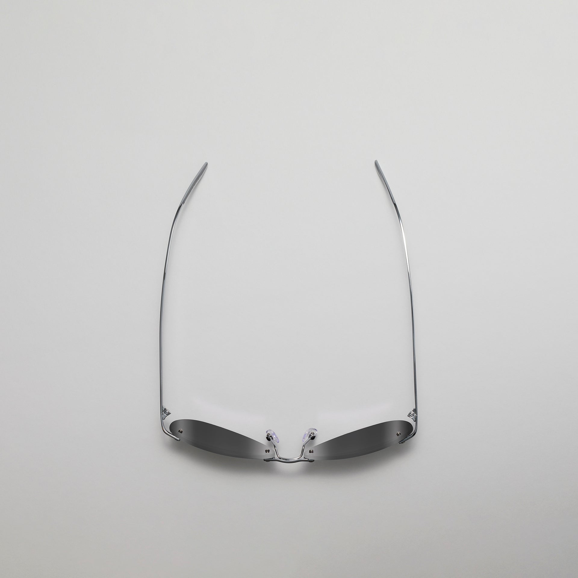 Silver eyeglass frame on a light gray background
