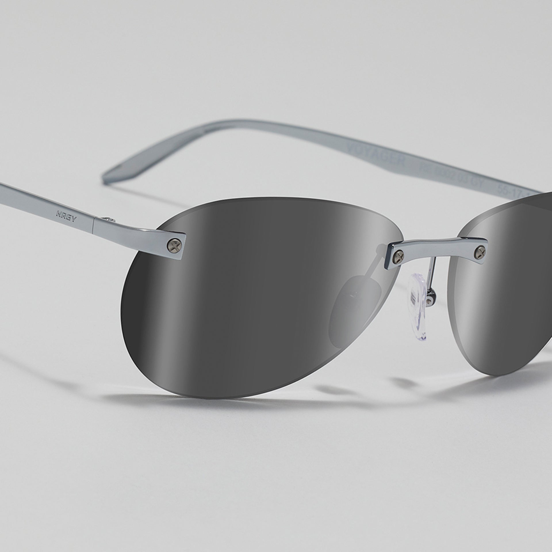 Sunglasses with gray lenses and thin metal frame on a light gray background