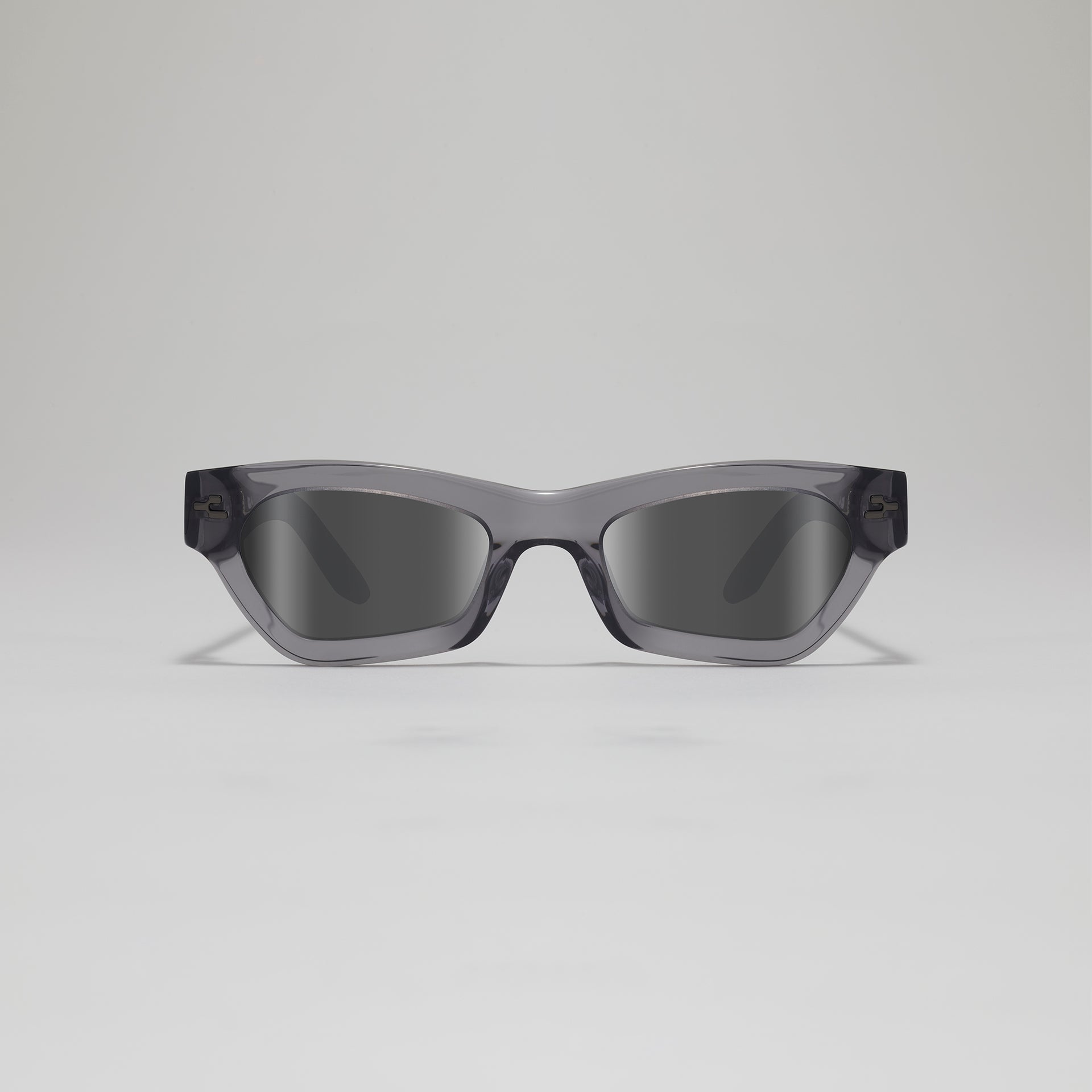 Sunglasses with a gray frame and dark lenses on a light gray background
