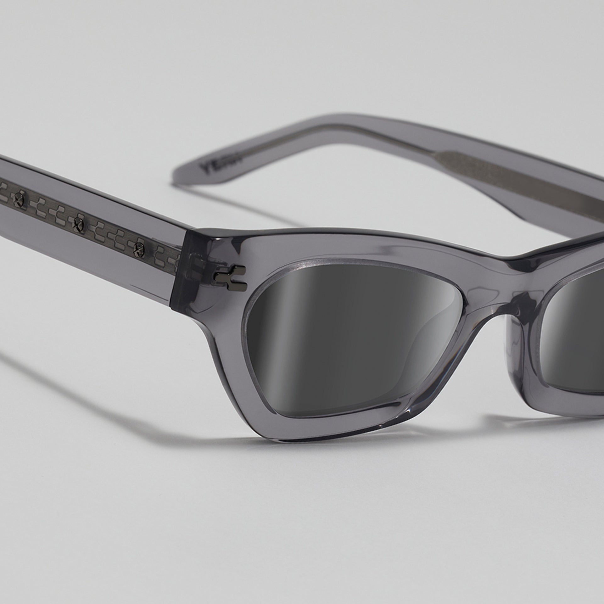 Gray sunglasses with reflective lenses on a light gray background