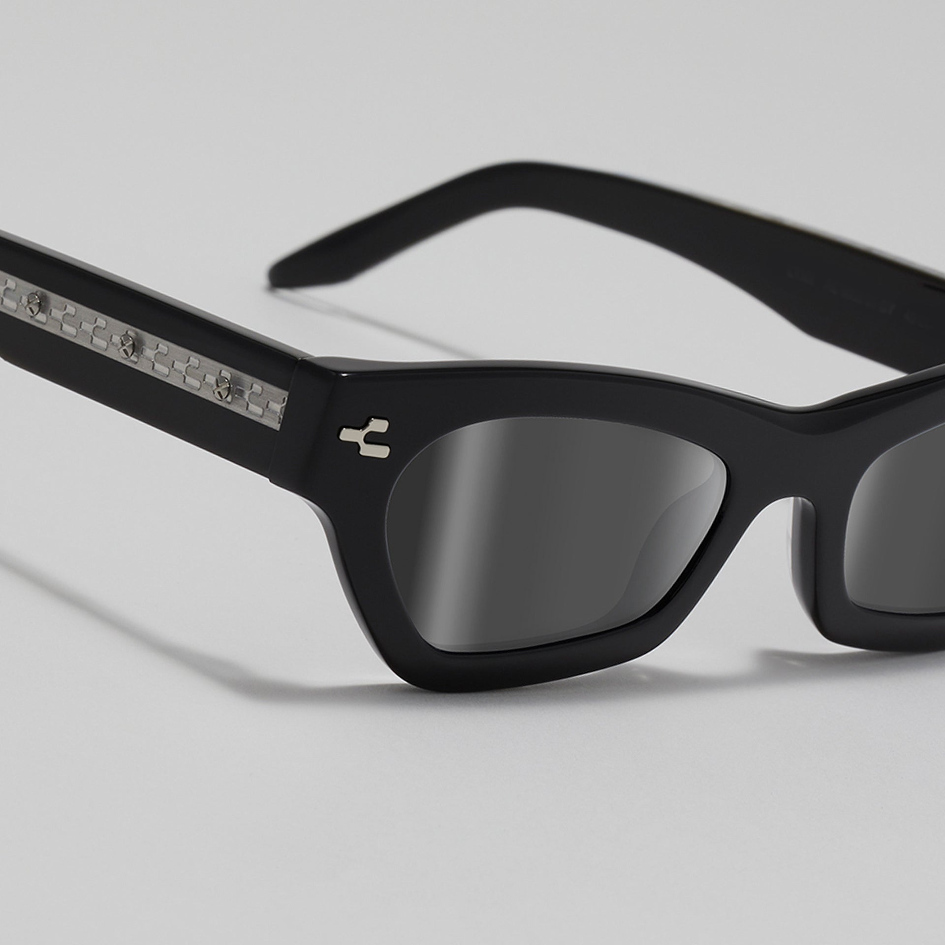Black sunglasses with reflective lenses on a light gray background