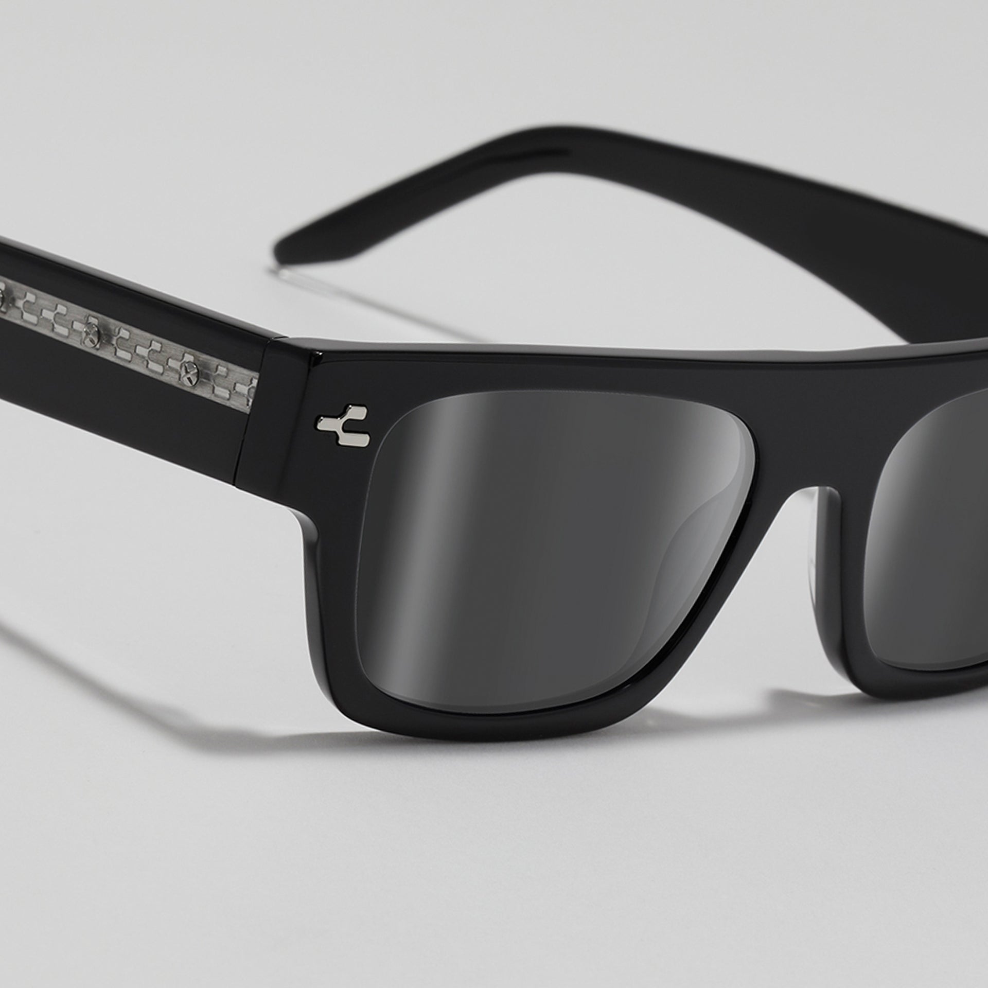 Black sunglasses with reflective lenses on a light gray background