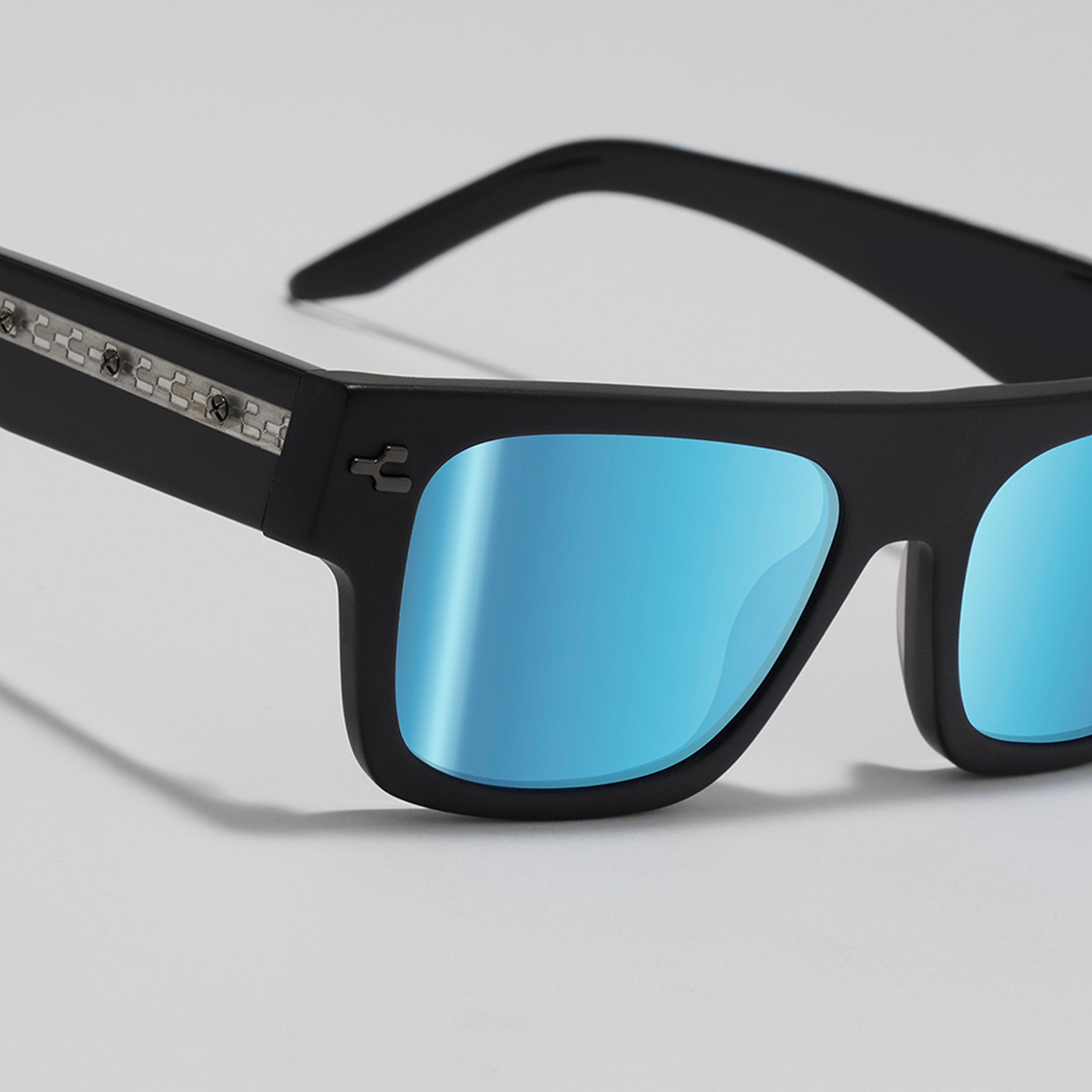 Black sunglasses with blue lenses on a light gray background