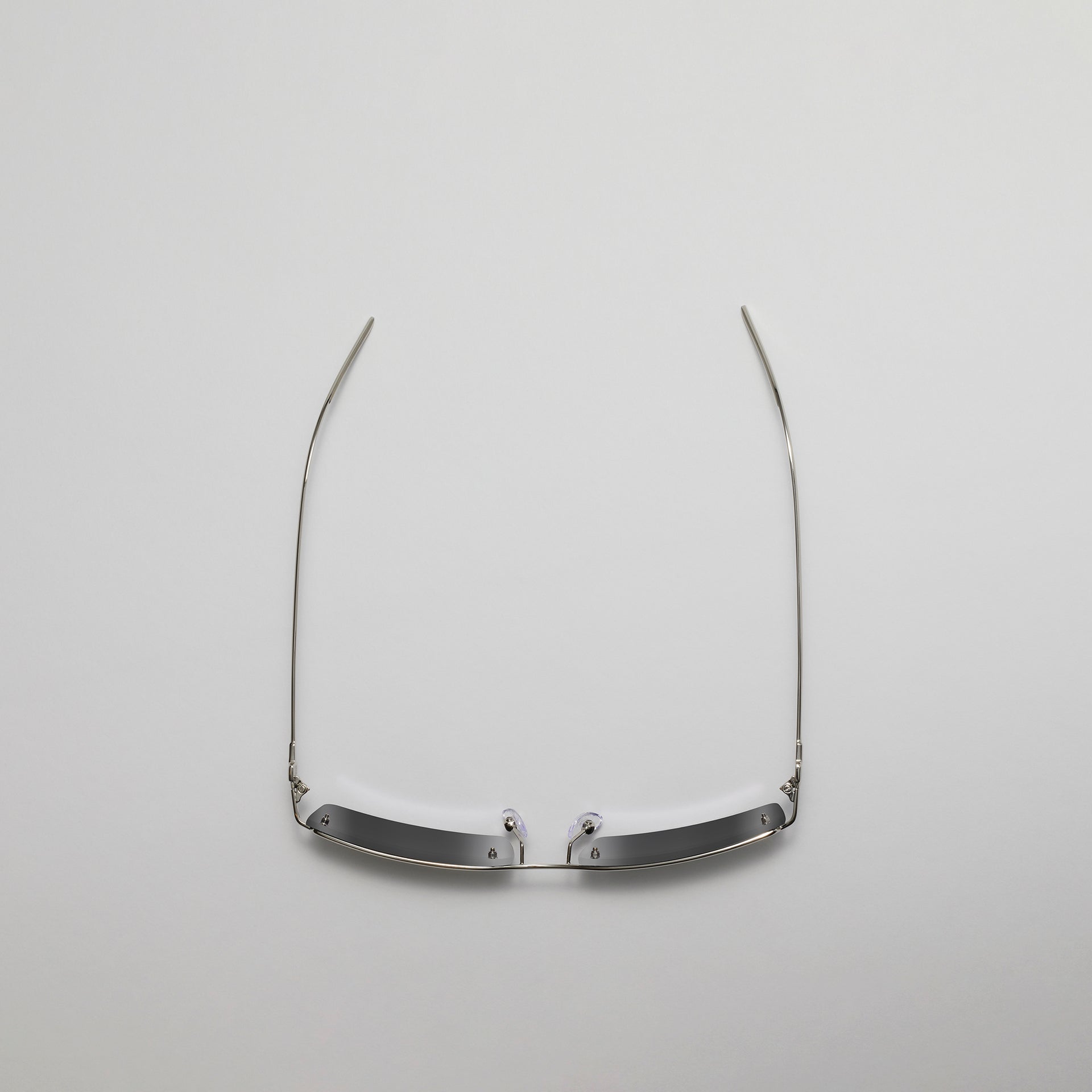 Silver eyeglass frame on a light gray background