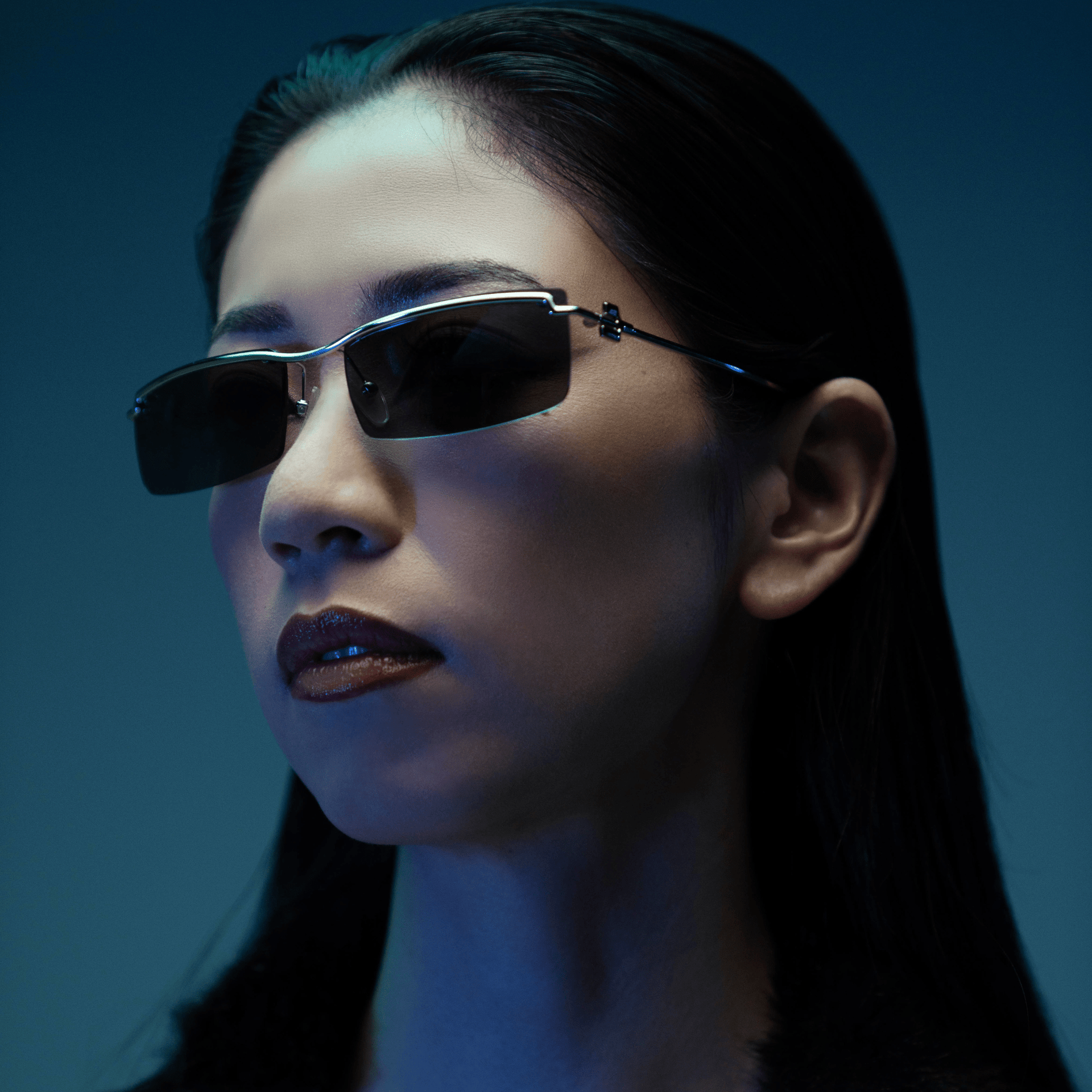 Person wearing sunglasses with a blue-toned background