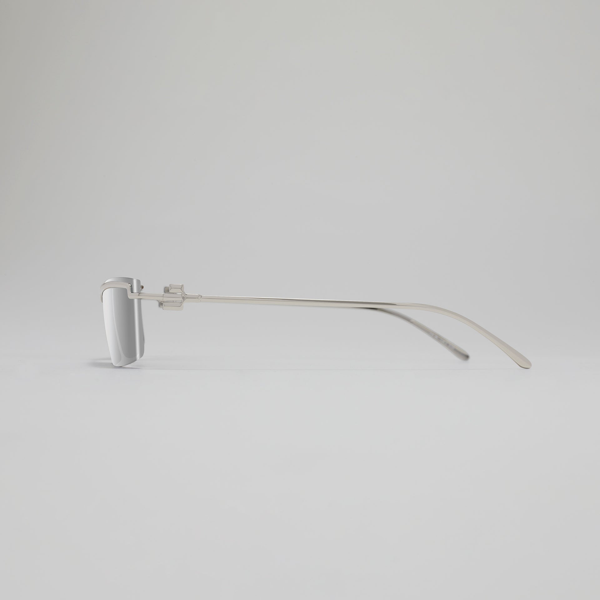 Silver eyeglass frame on a light gray background