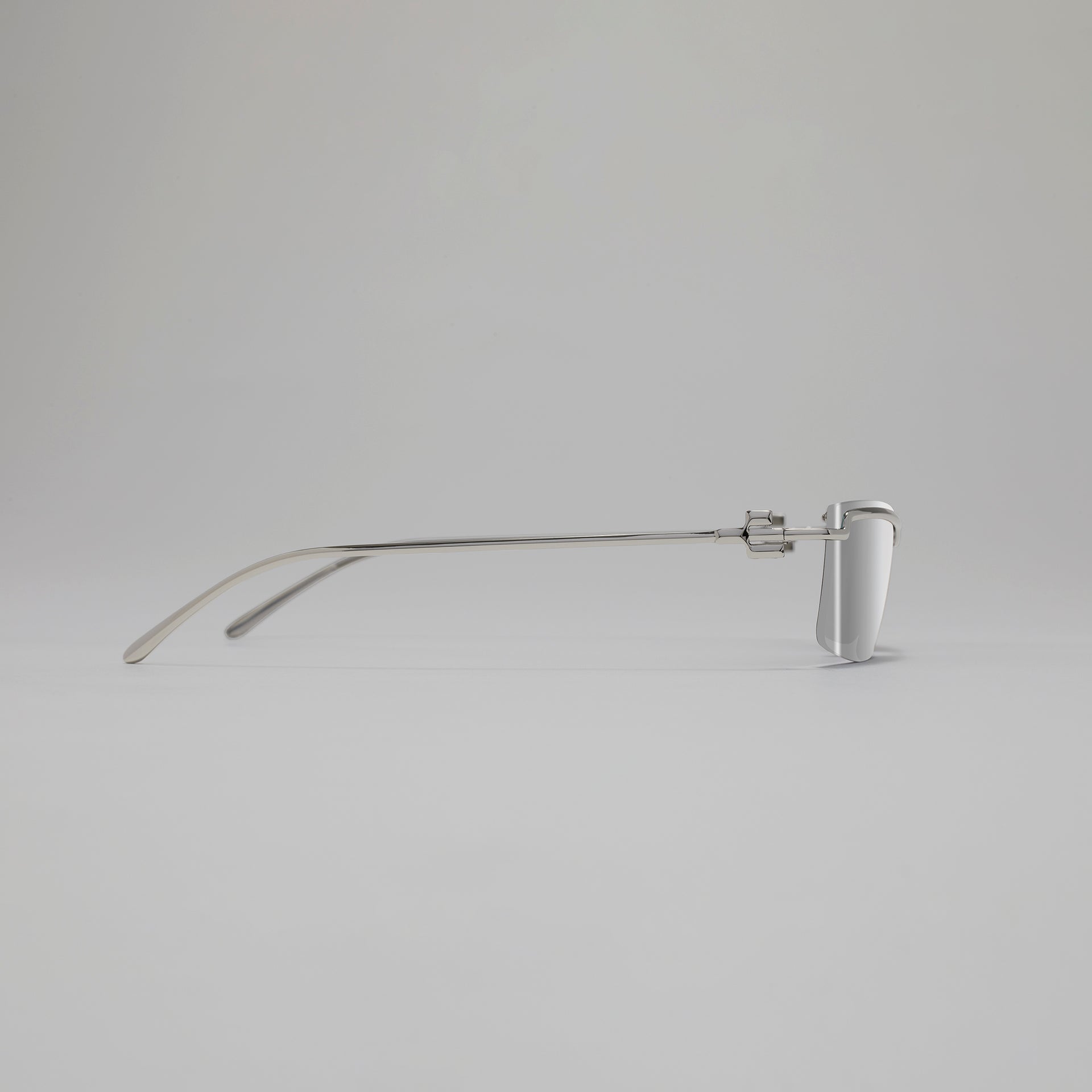Silver eyeglasses on a light gray background