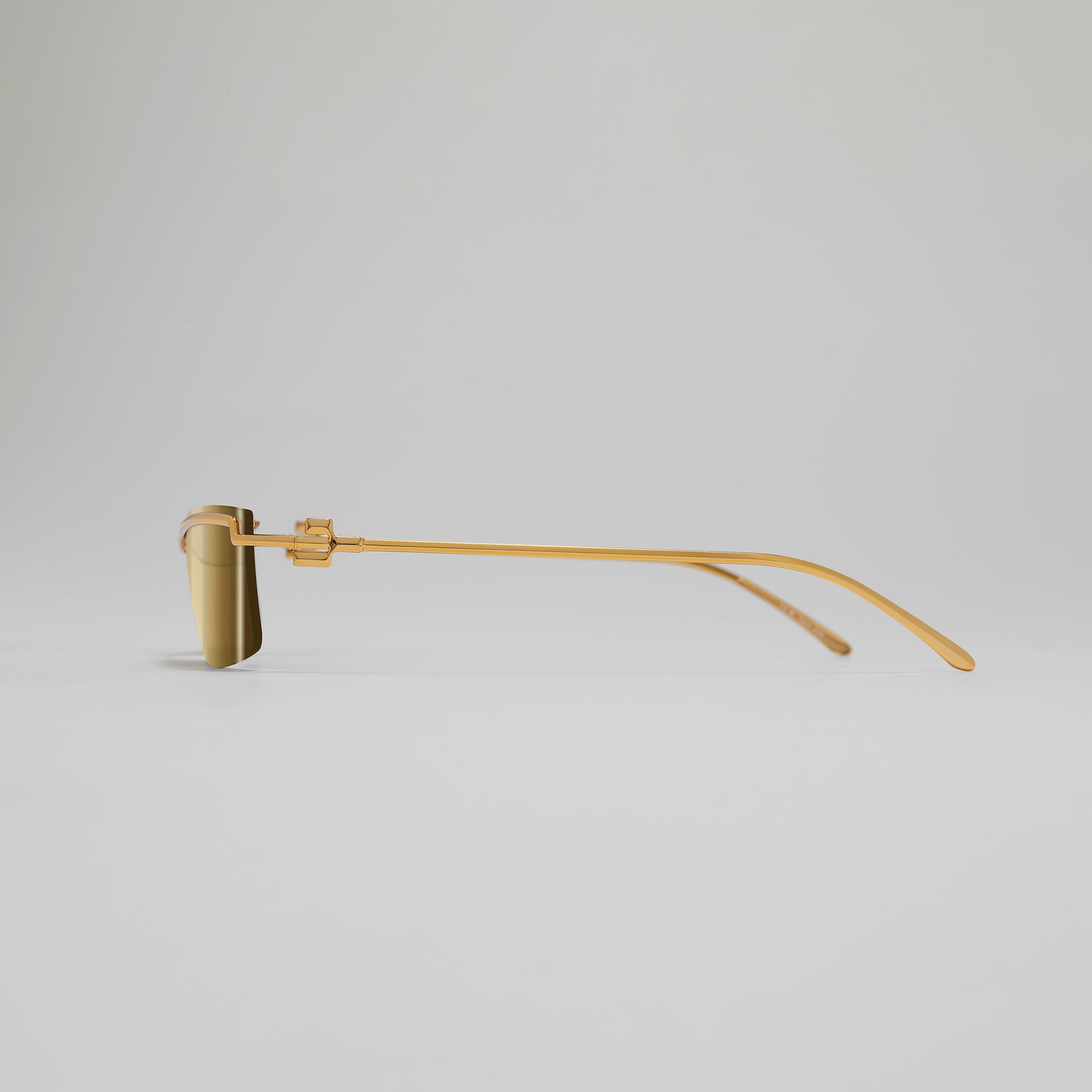 Gold eyeglasses on a light gray background
