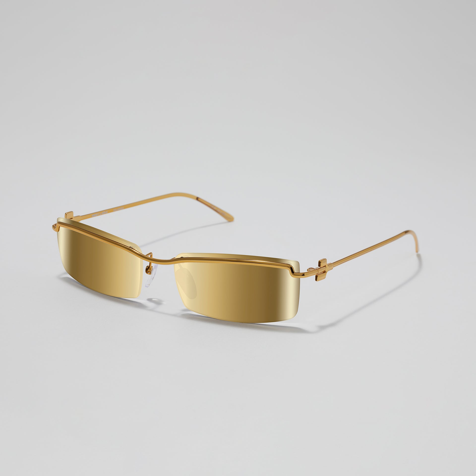 Gold sunglasses on a light gray background