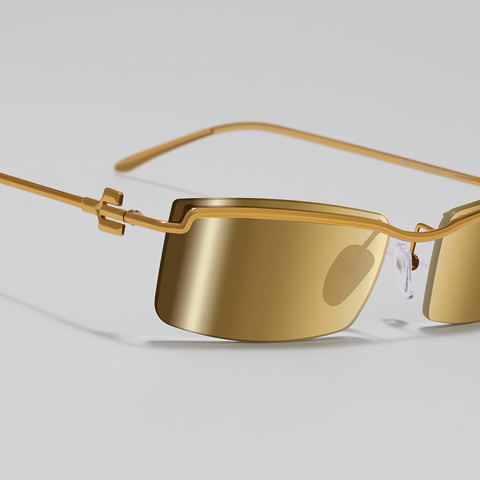 Gold sunglasses with a plain background