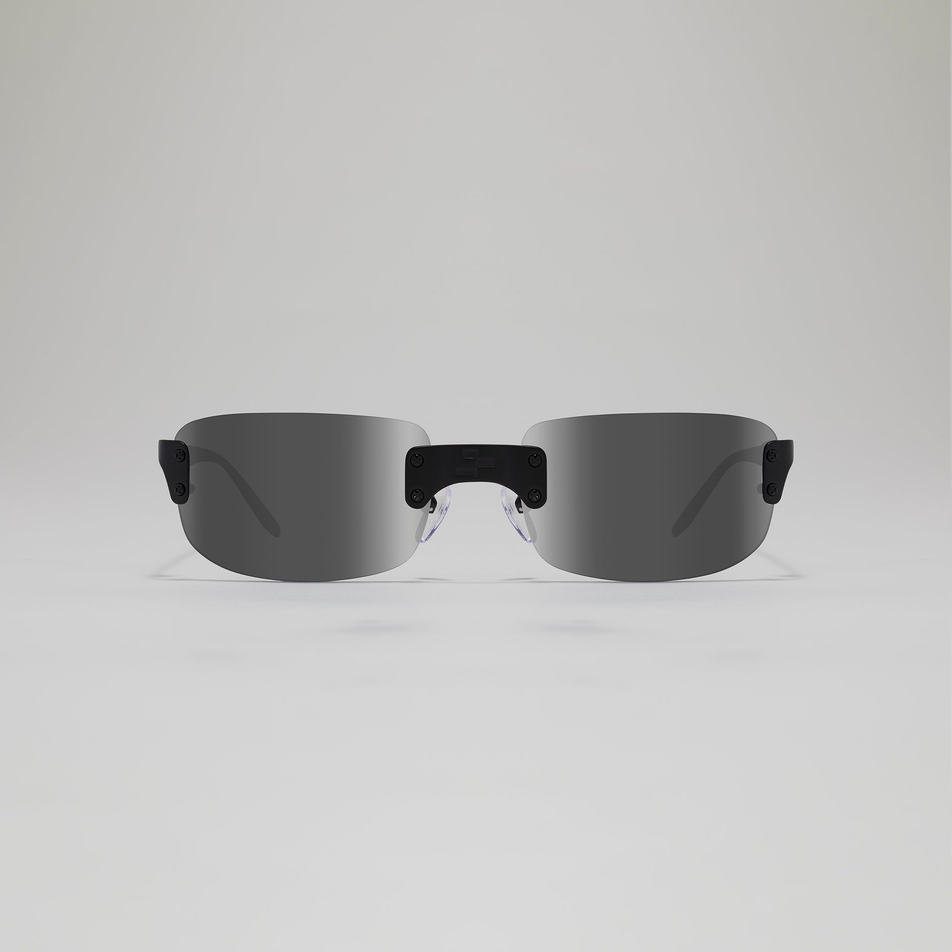 Sunglasses with black frames and reflective lenses on a light gray background