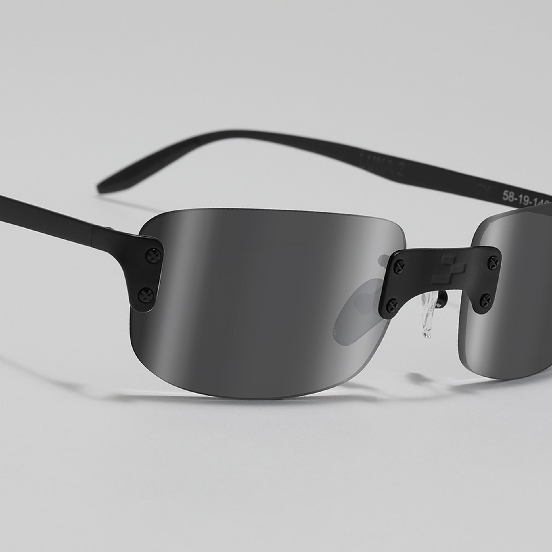 Black sunglasses with reflective lenses on a light gray background
