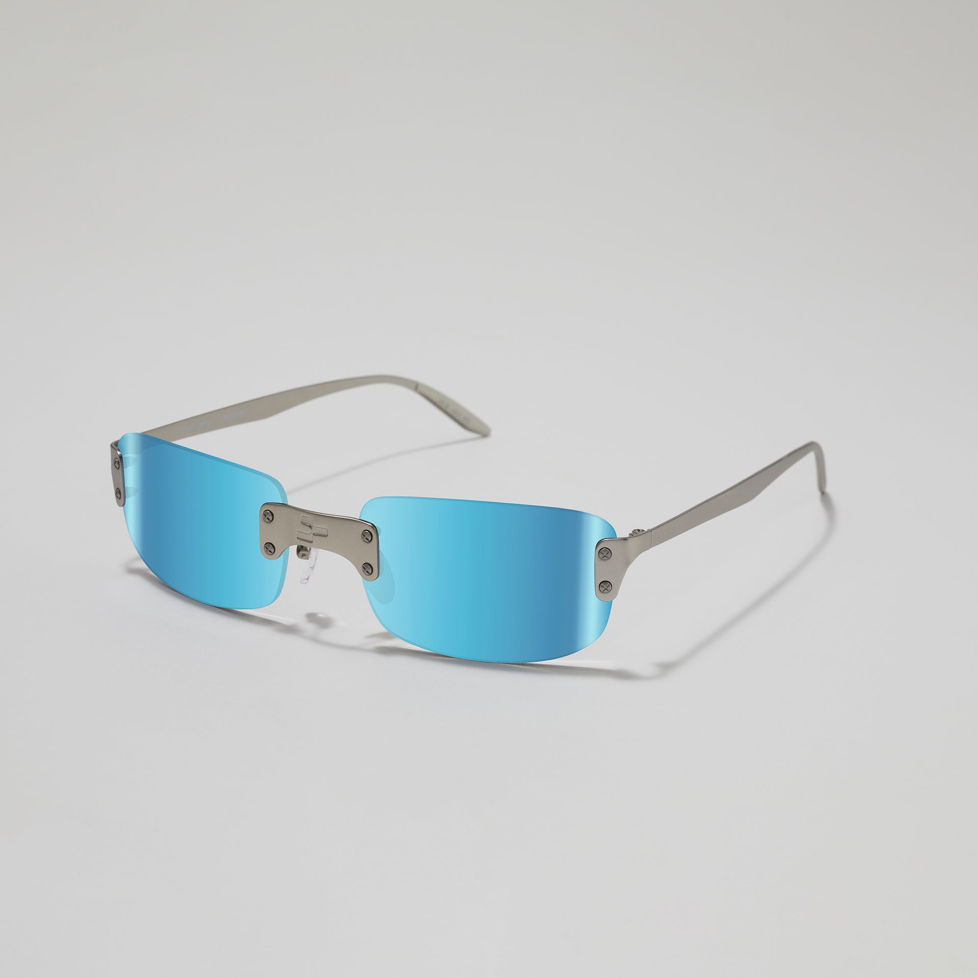 Sunglasses with blue lenses and silver frames on a light gray background
