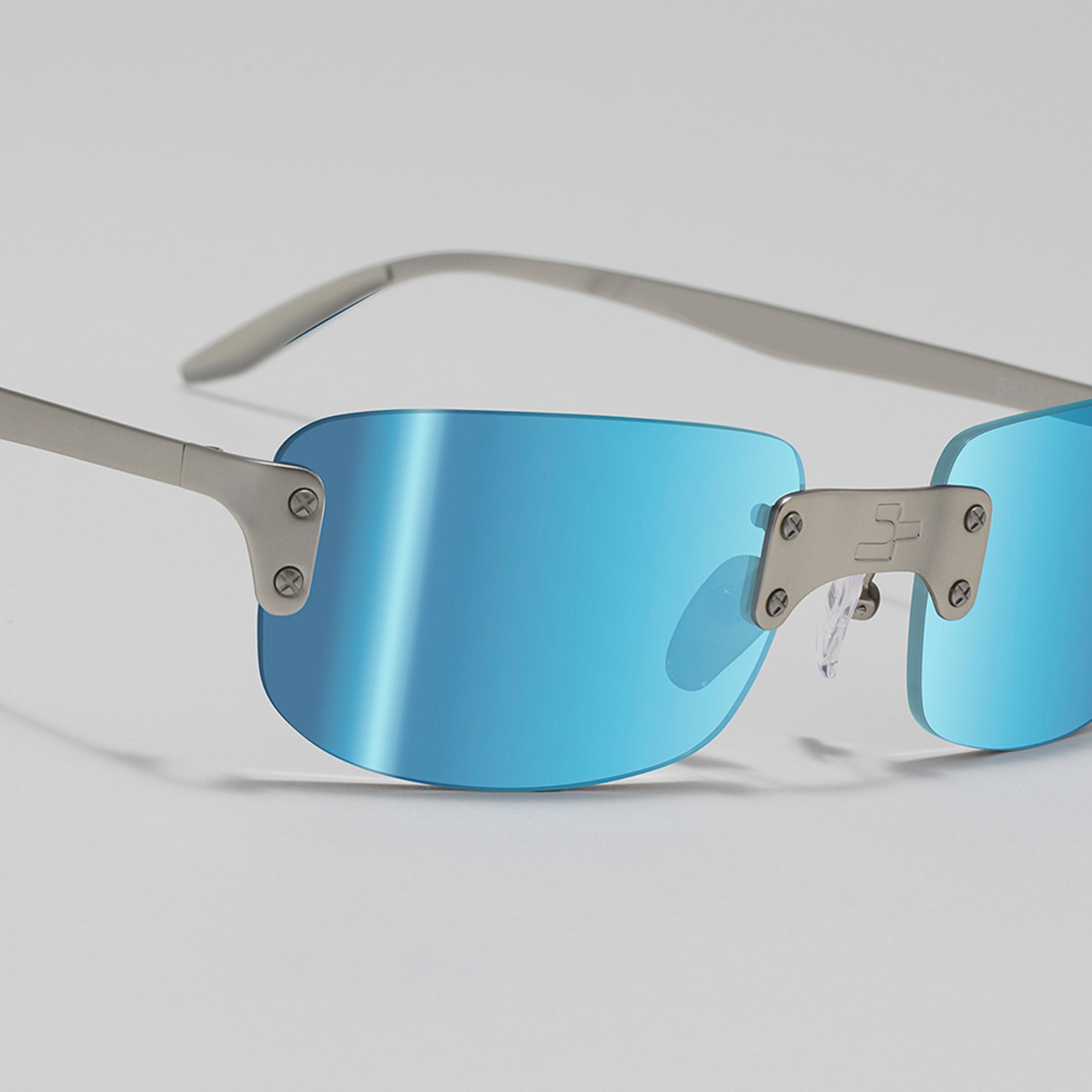 Sunglasses with blue lenses and silver frames on a light gray background