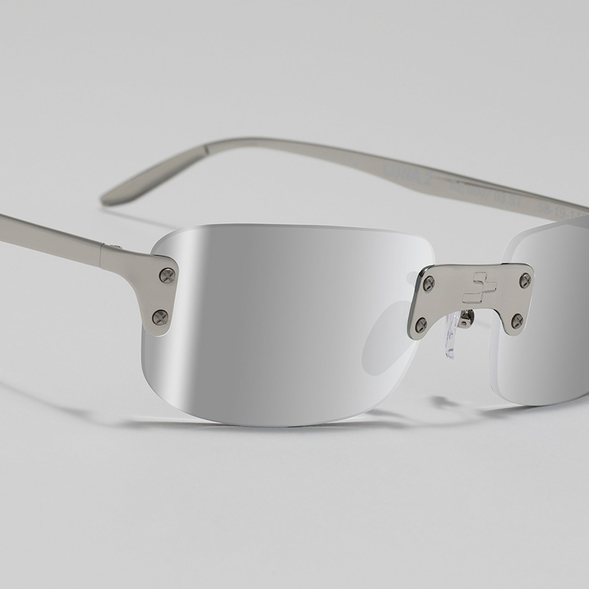 Silver-framed sunglasses on a light gray background