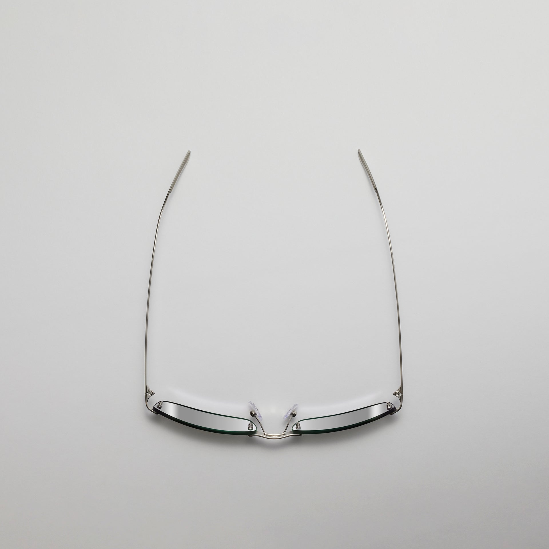 Silver eyeglass frame on a light gray background