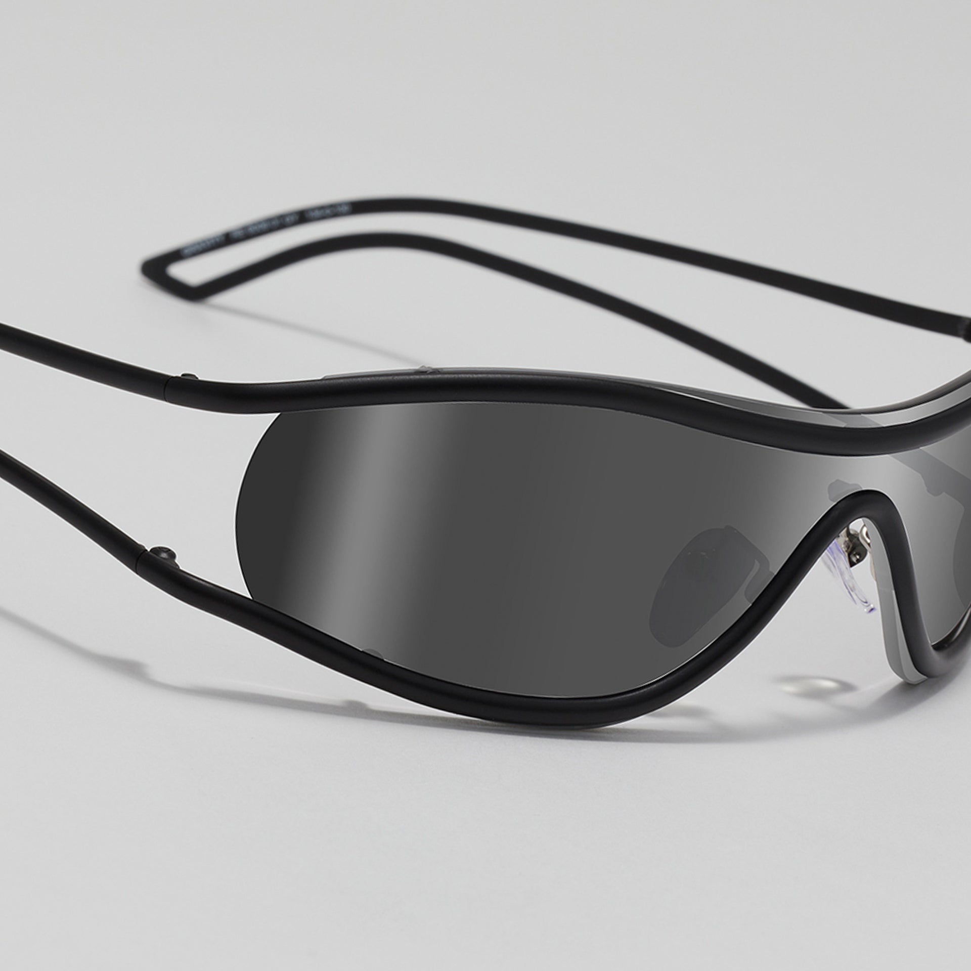 Black sunglasses with a reflective lens on a light gray background