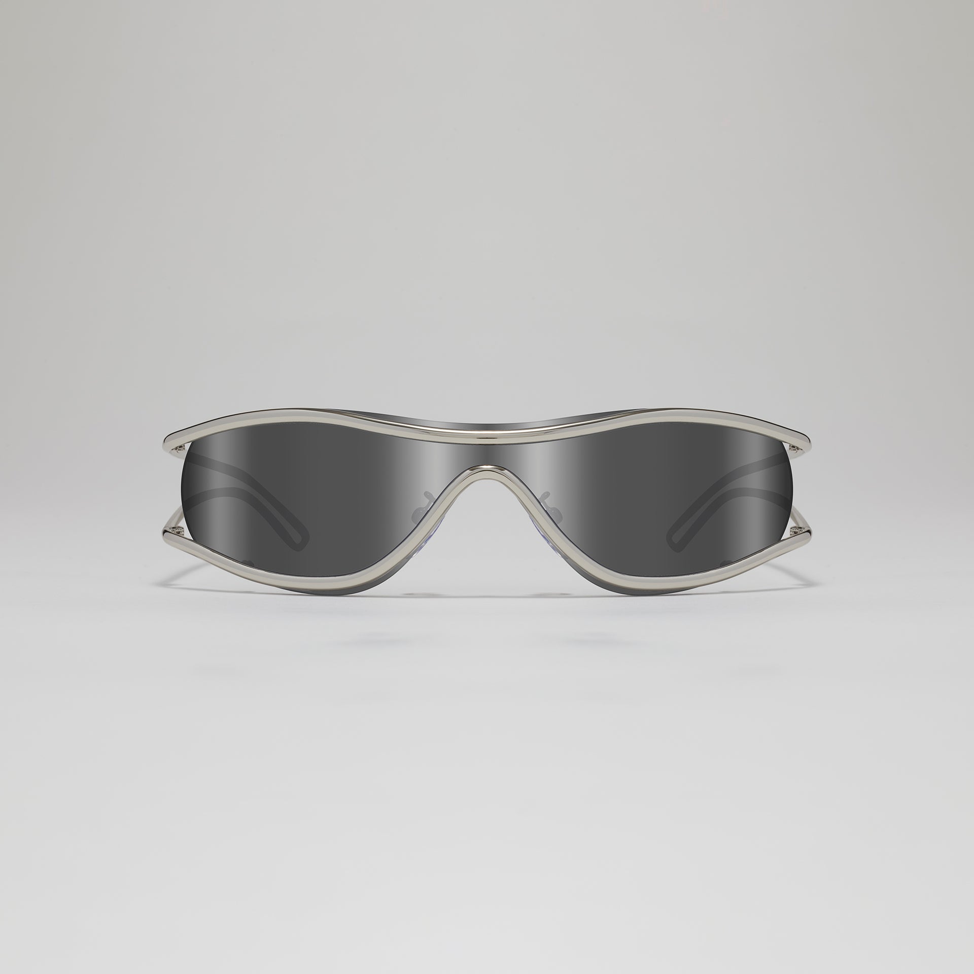Sunglasses with a clear frame and dark lenses on a light gray background