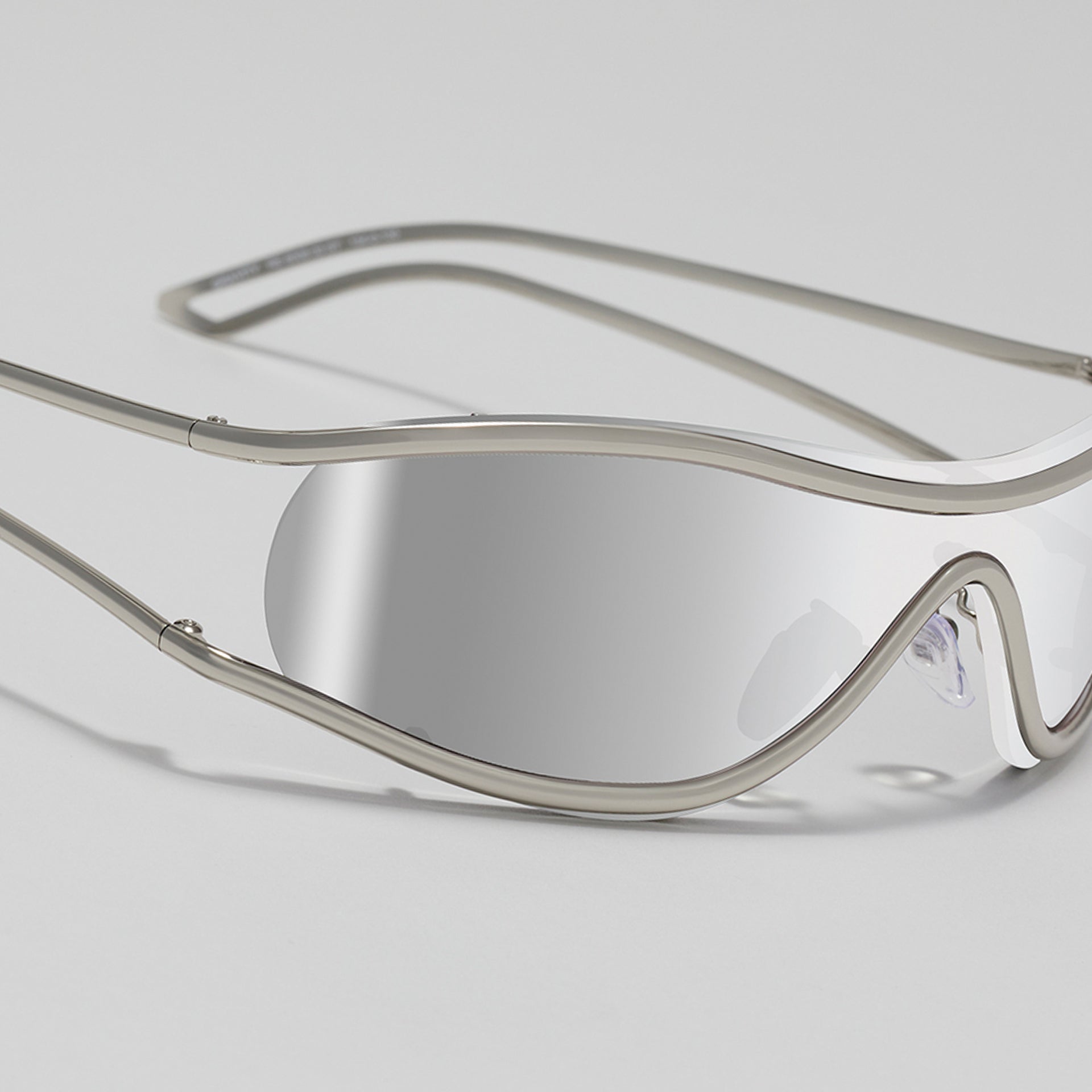 Silver-framed sunglasses on a light gray background
