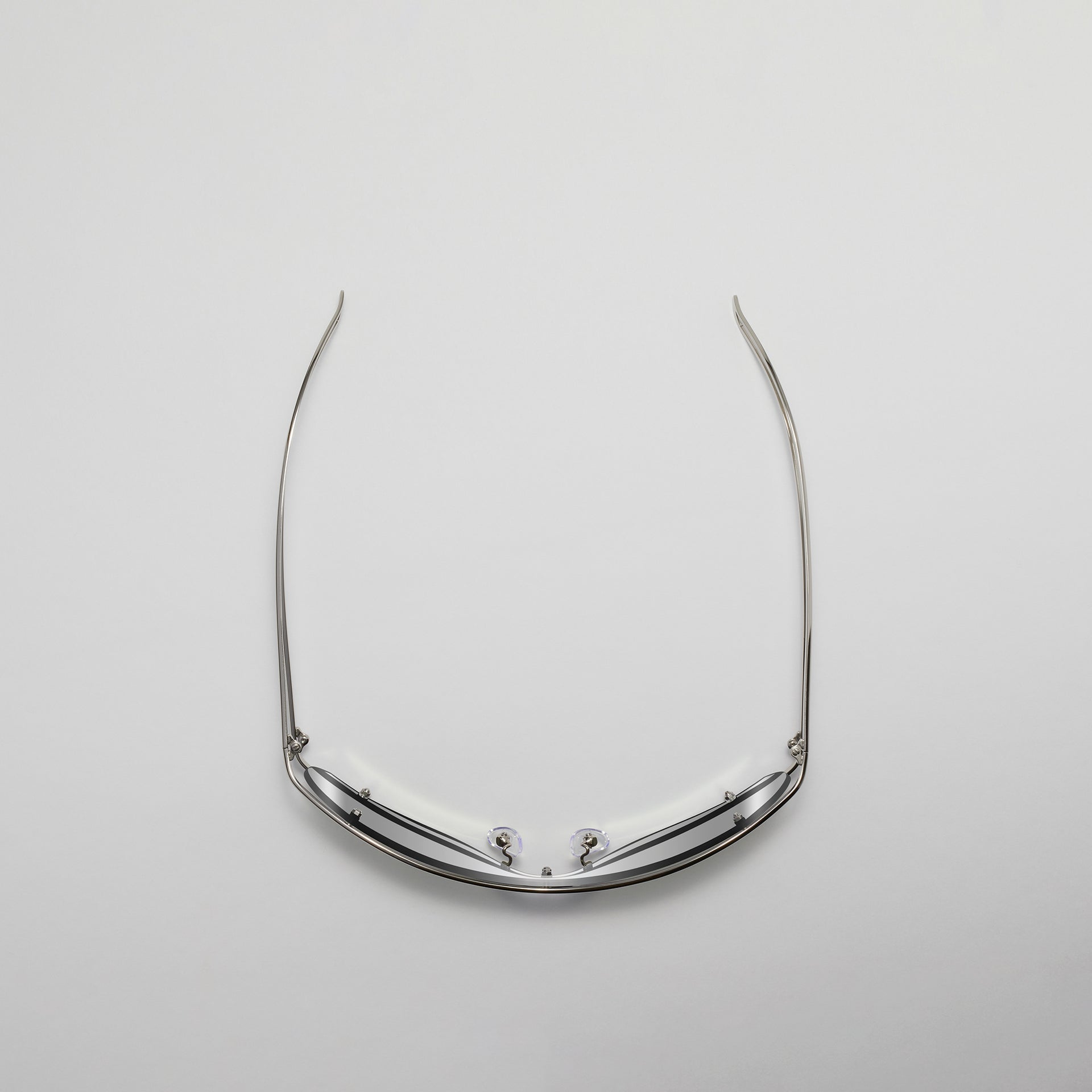 Silver eyeglass frame on a light gray background