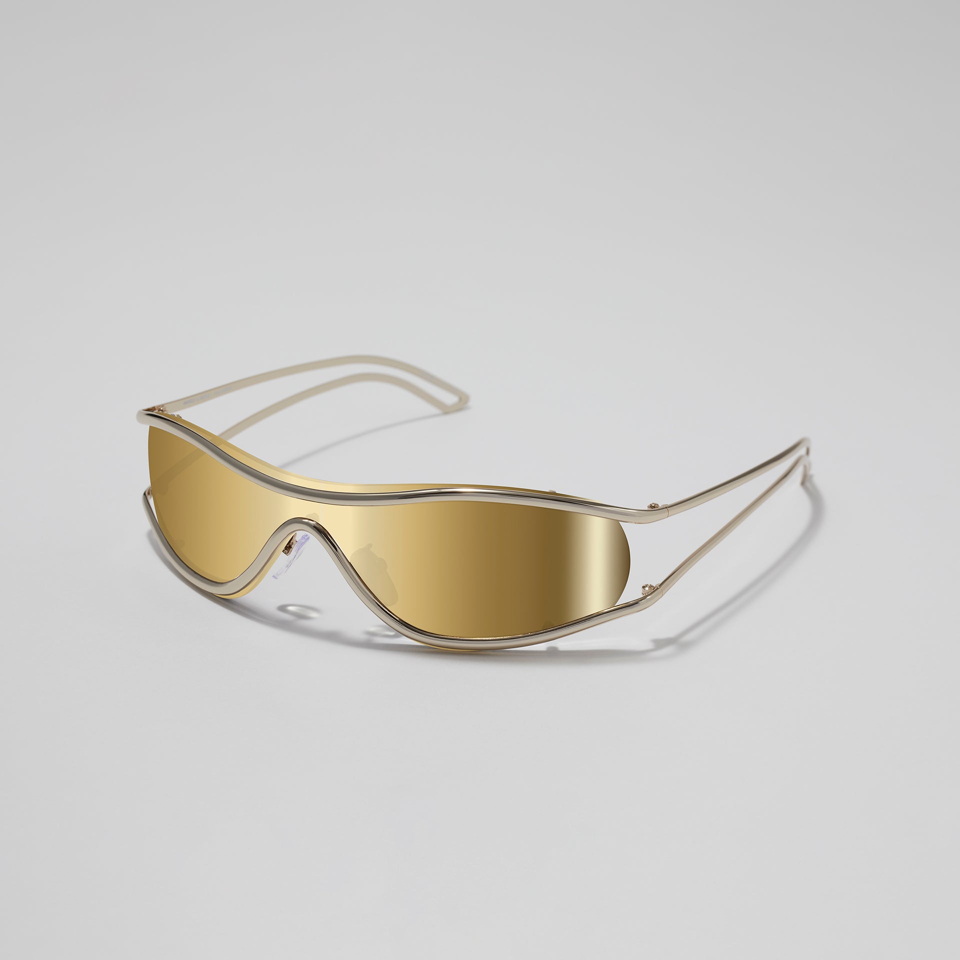 Gold-framed sunglasses on a light gray background