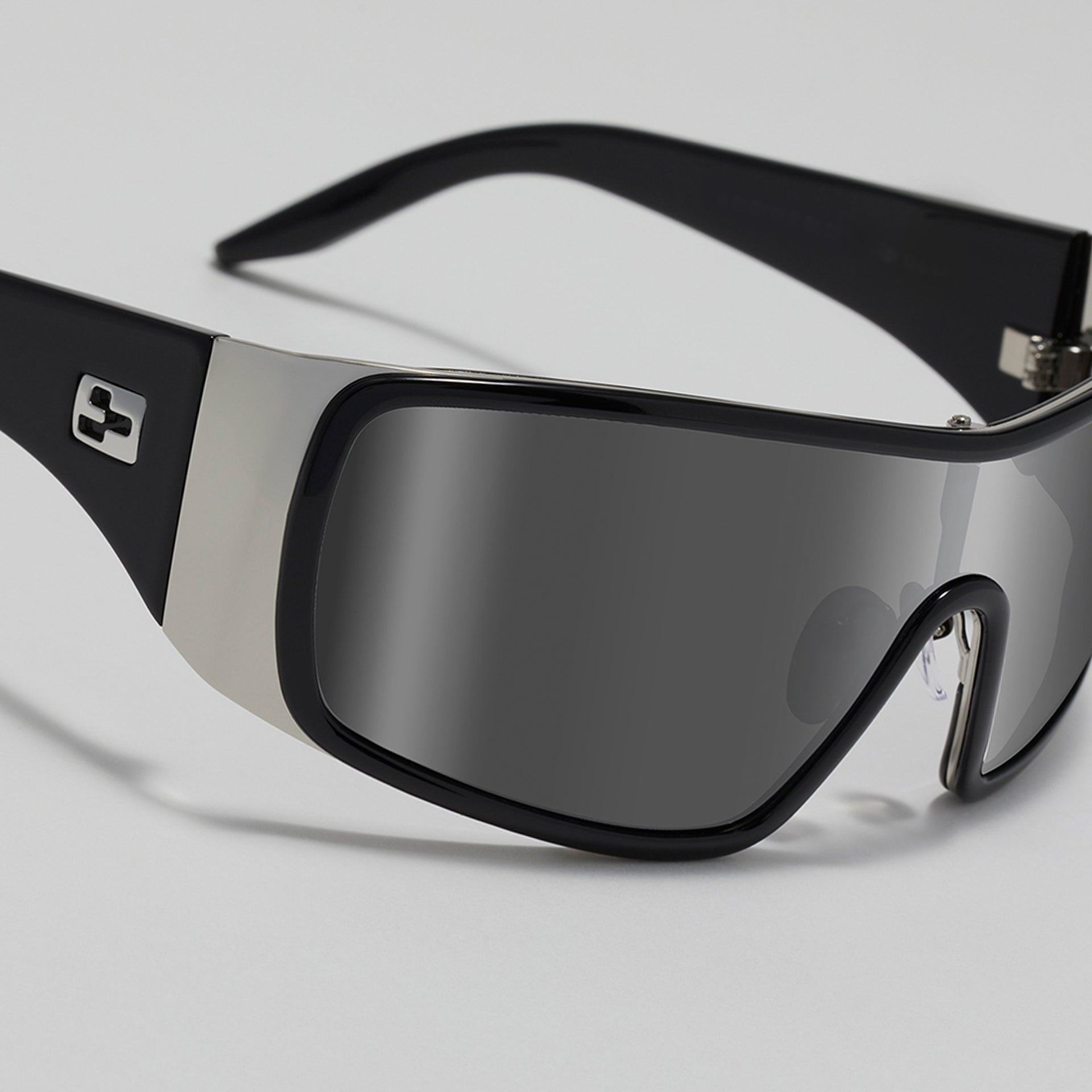 Black sunglasses with reflective lenses on a light gray background
