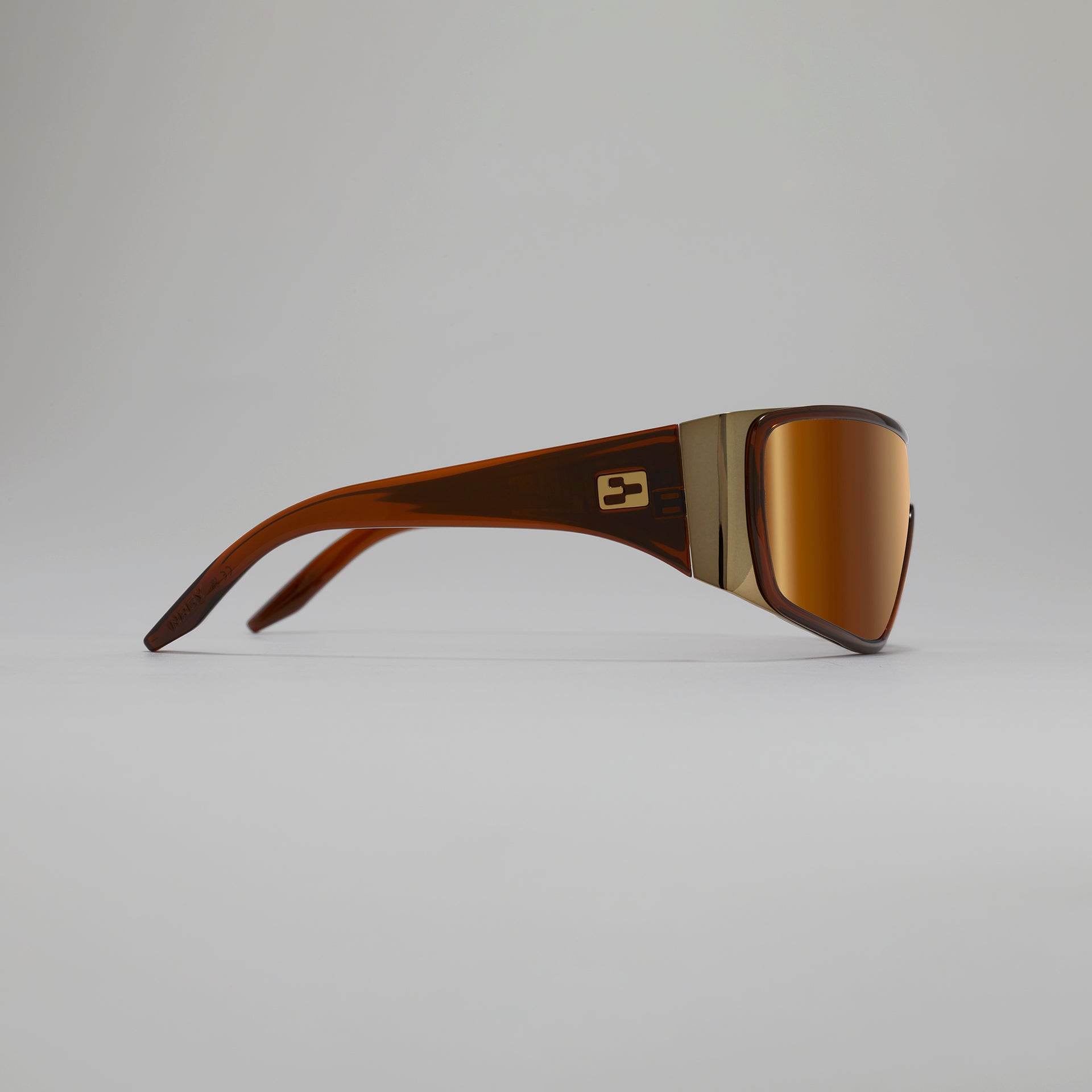 Brown sunglasses with a gold frame on a gray background