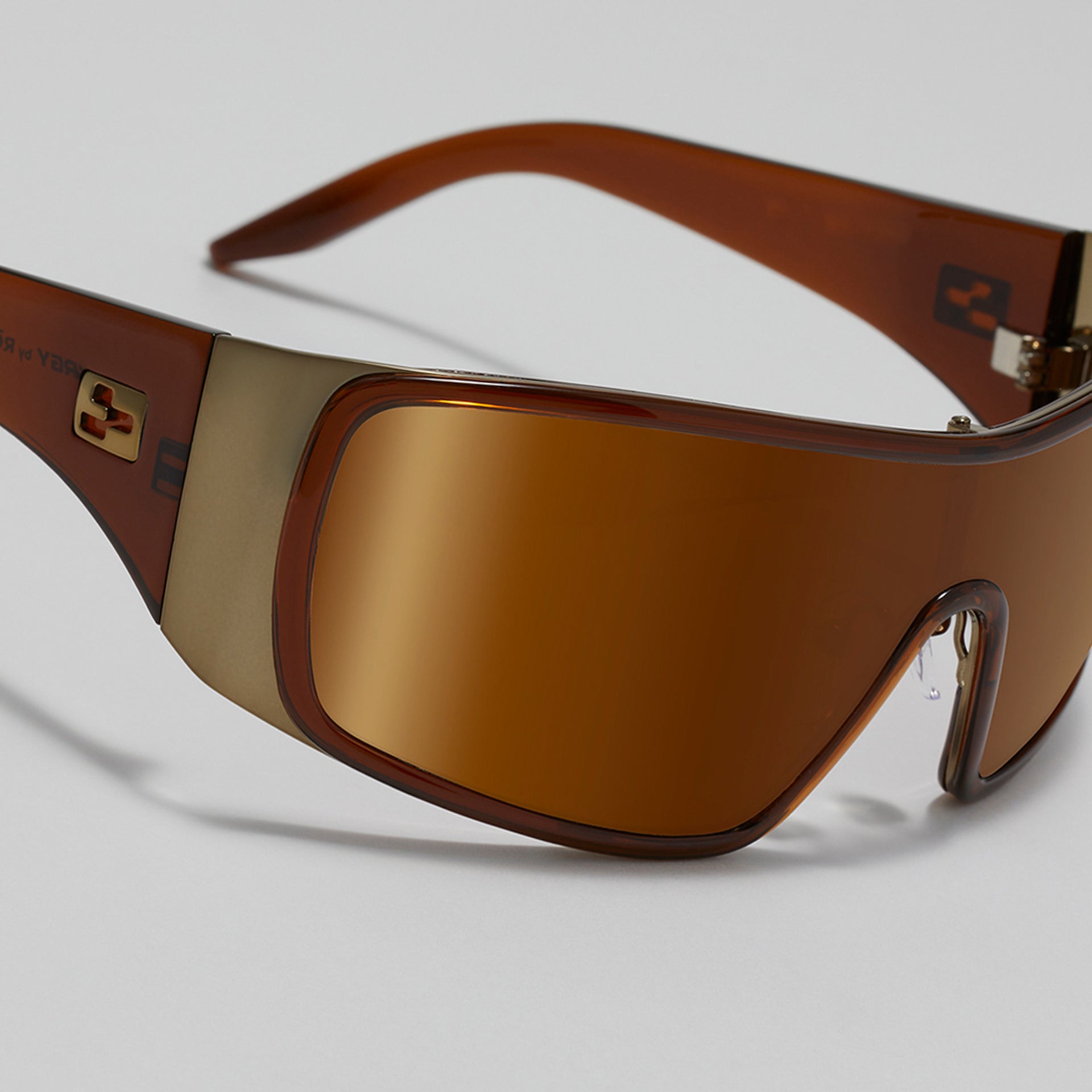 Brown sunglasses with a reflective lens on a light gray background