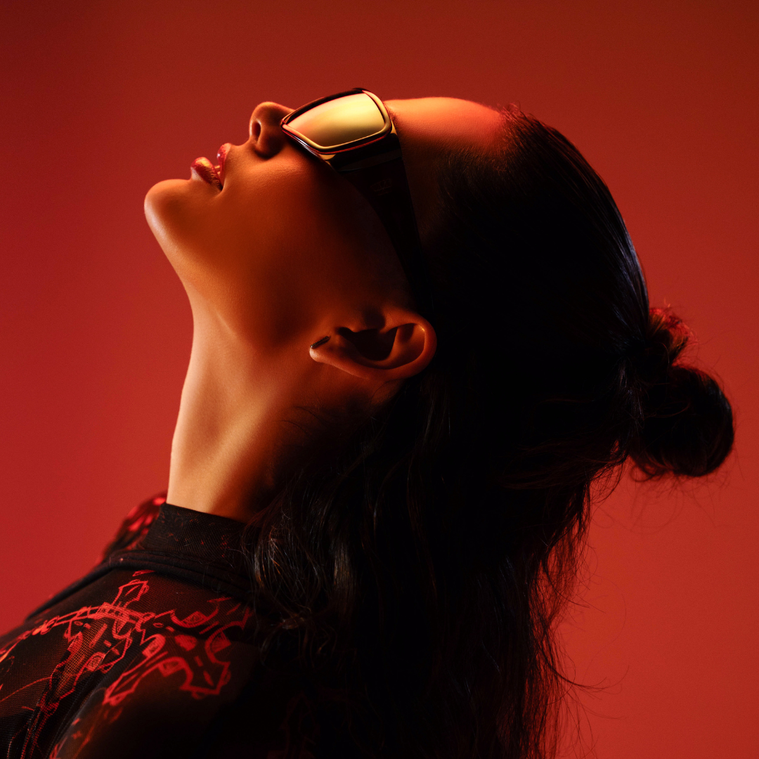 Person wearing futuristic goggles against a red background