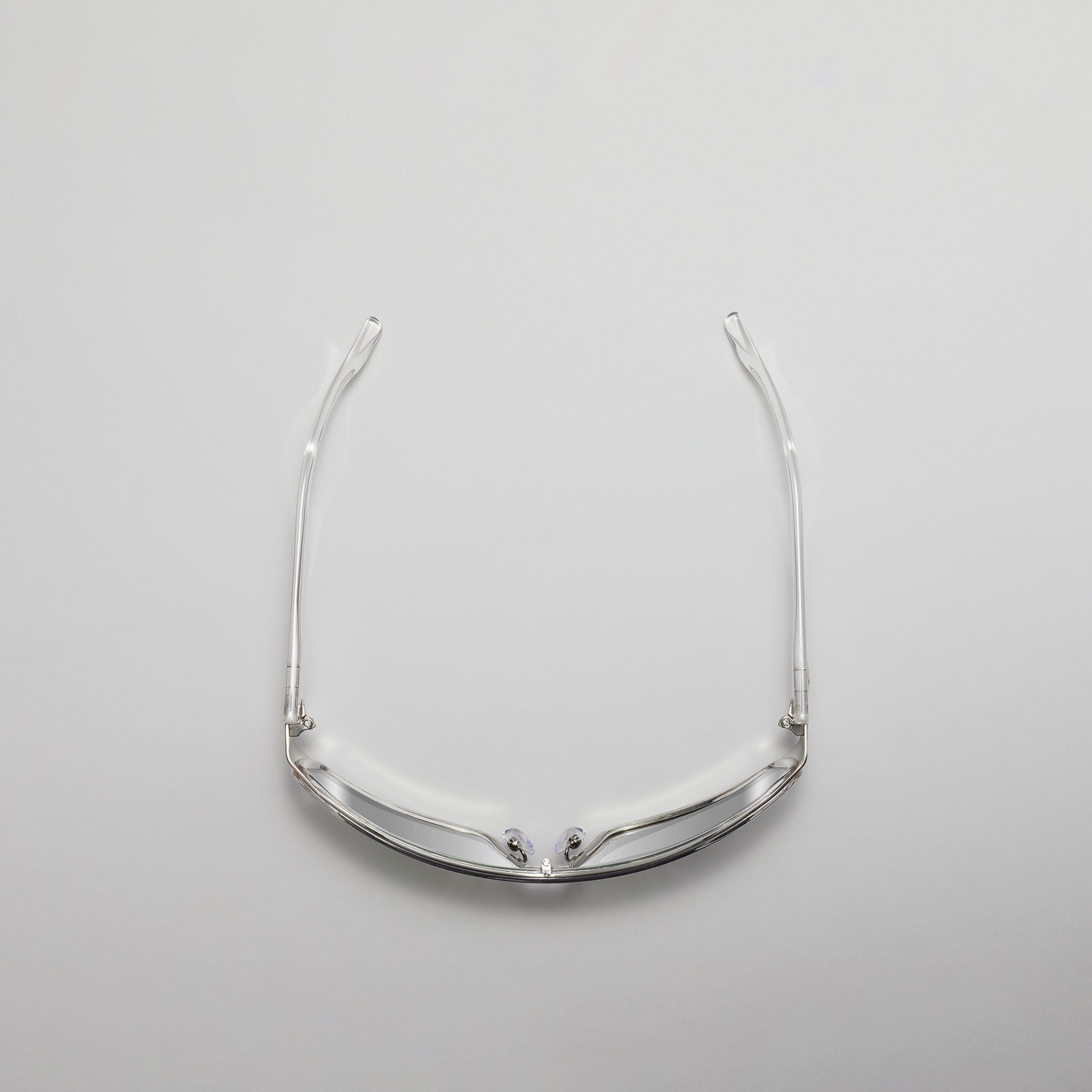 Clear eyeglass frame on a light gray background
