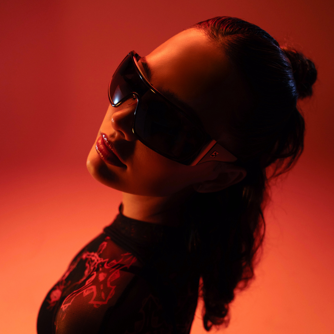 Person wearing sunglasses with a red-orange background