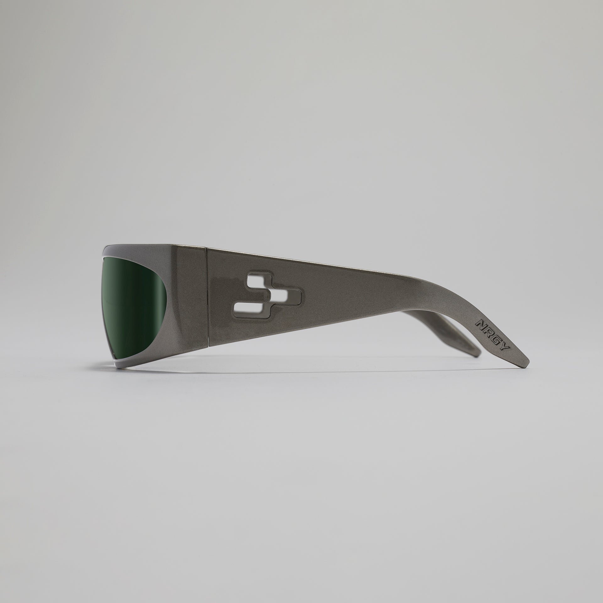 Sunglasses with a dark frame and green lenses on a light gray background
