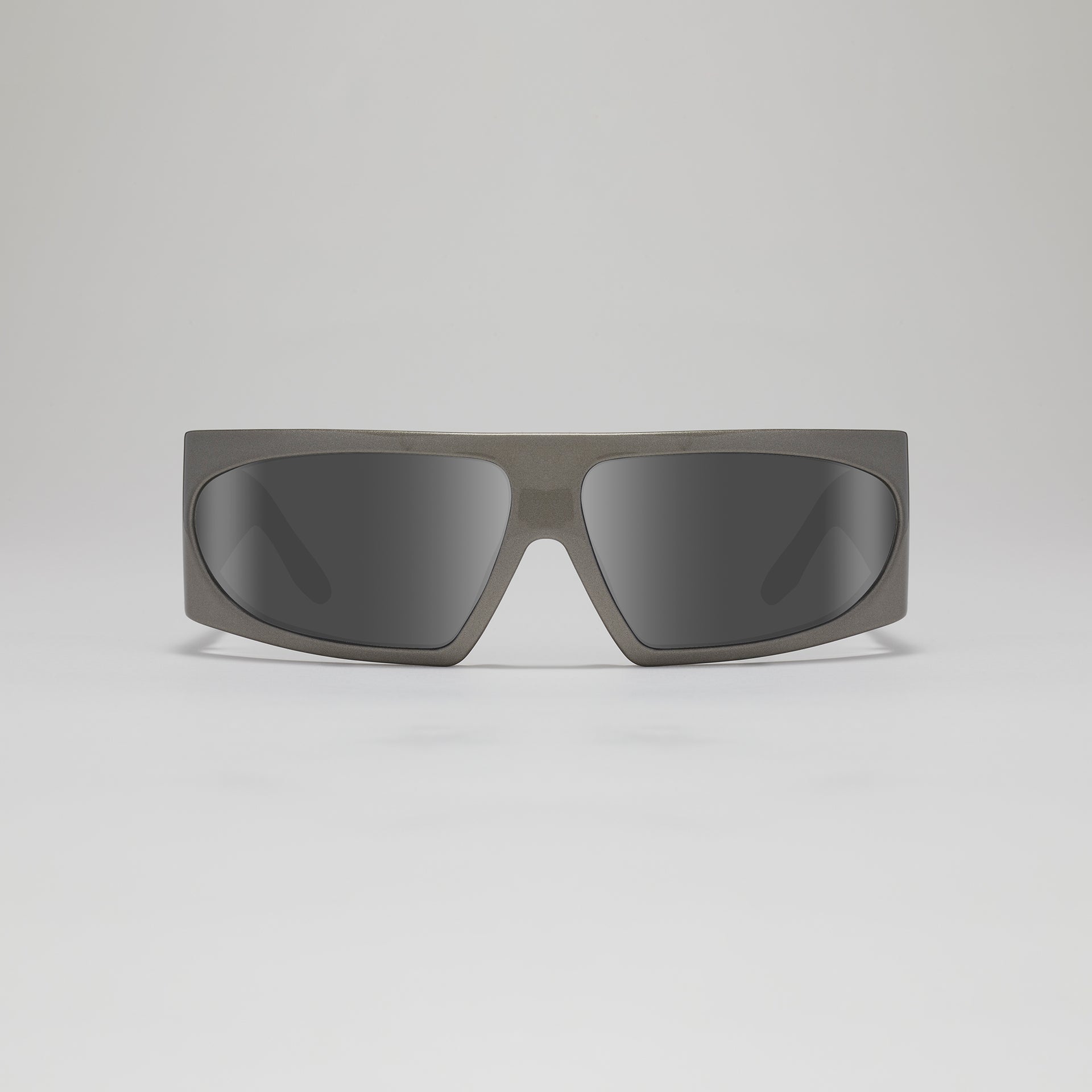 Sunglasses with a gray frame and dark lenses on a light gray background