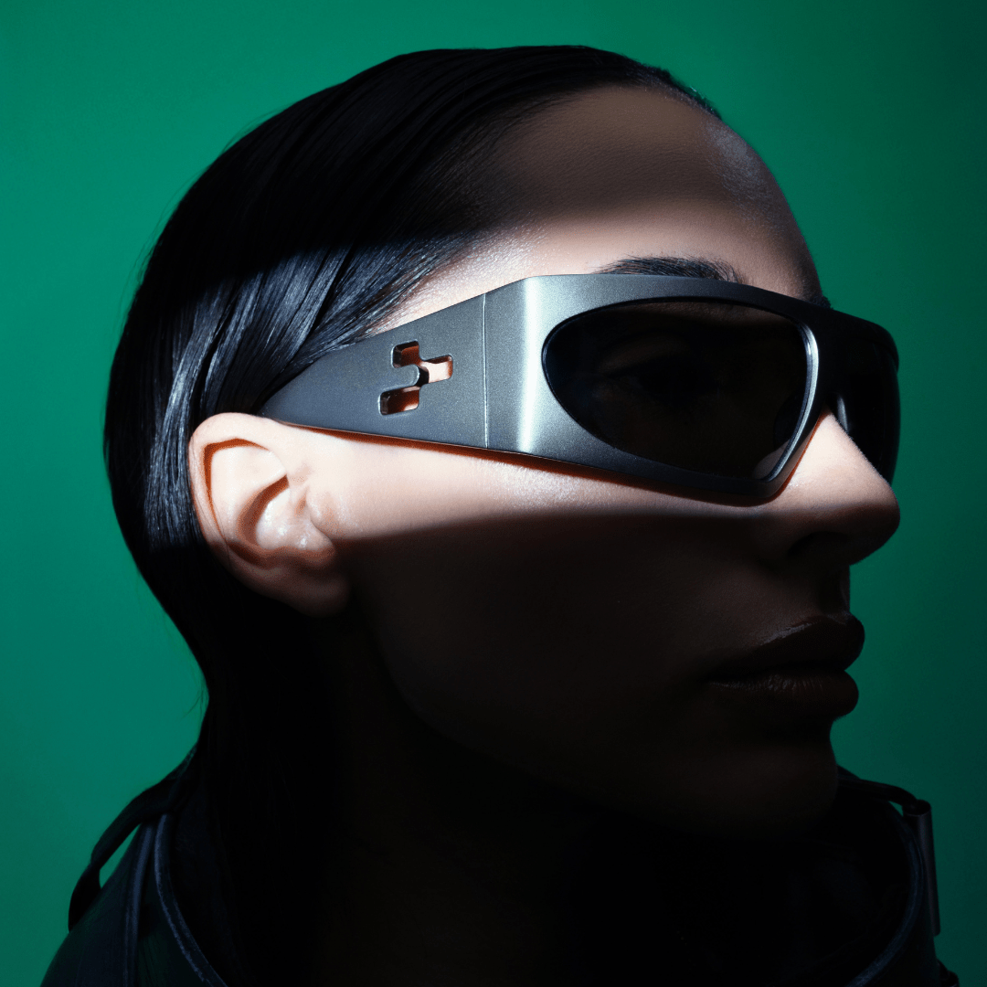 Person wearing futuristic sunglasses with a green background