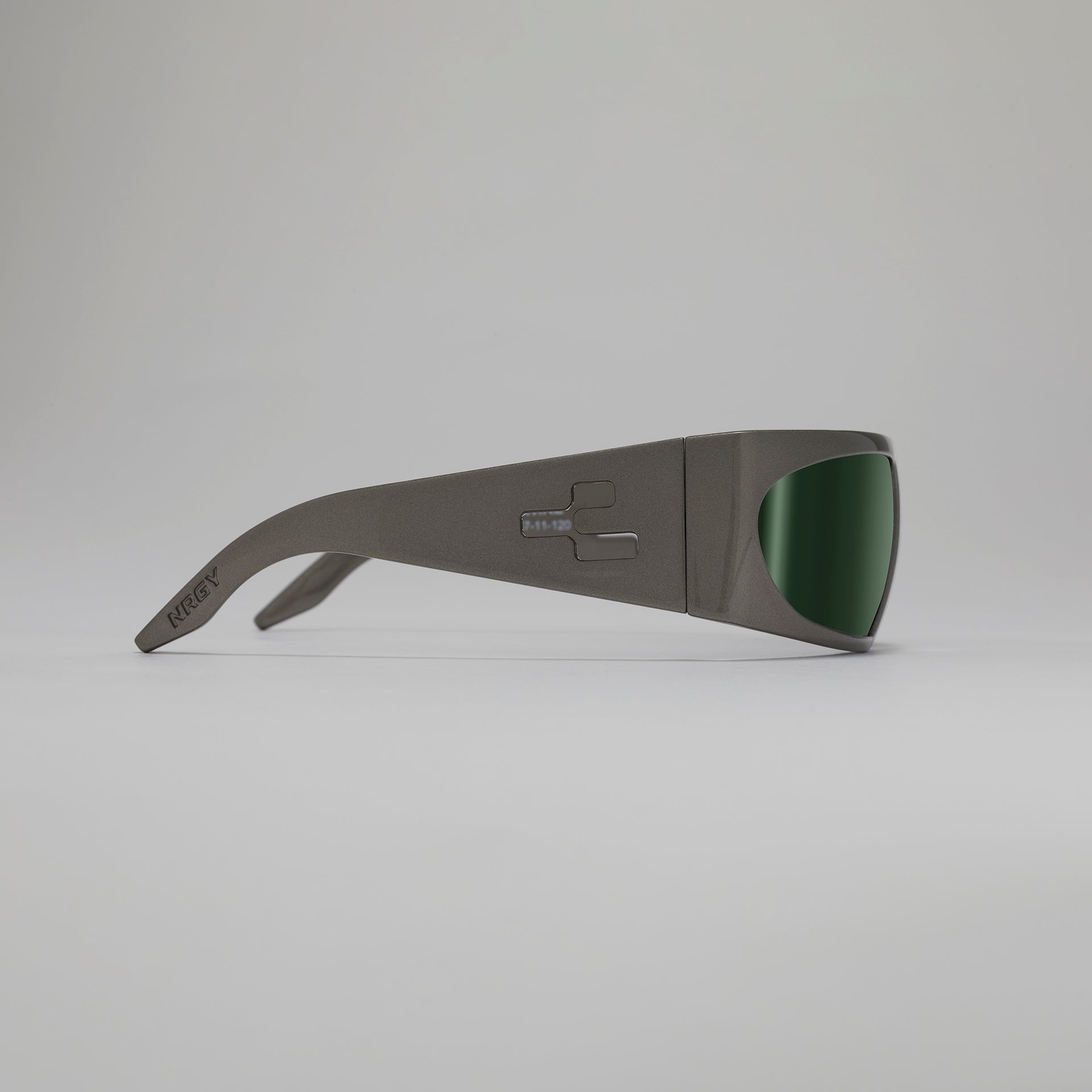 Sunglasses with a dark frame and green lenses on a light gray background