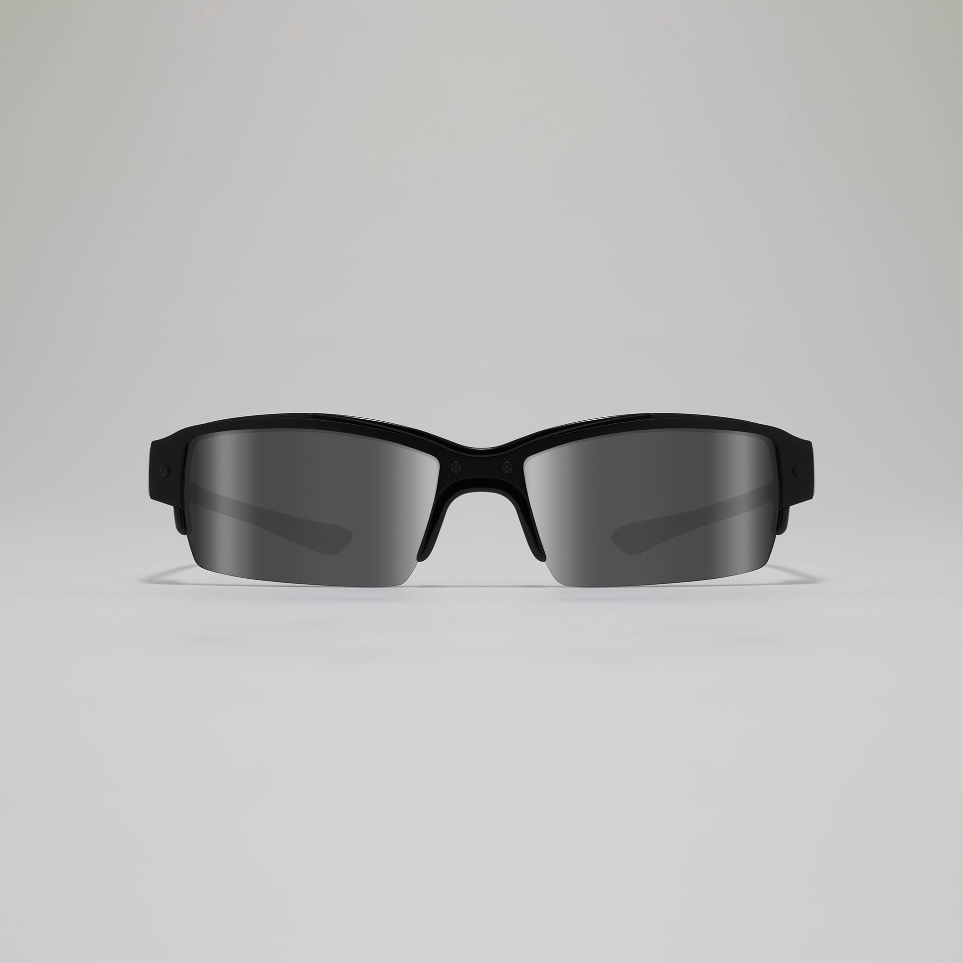 Black sunglasses with reflective lenses on a light gray background