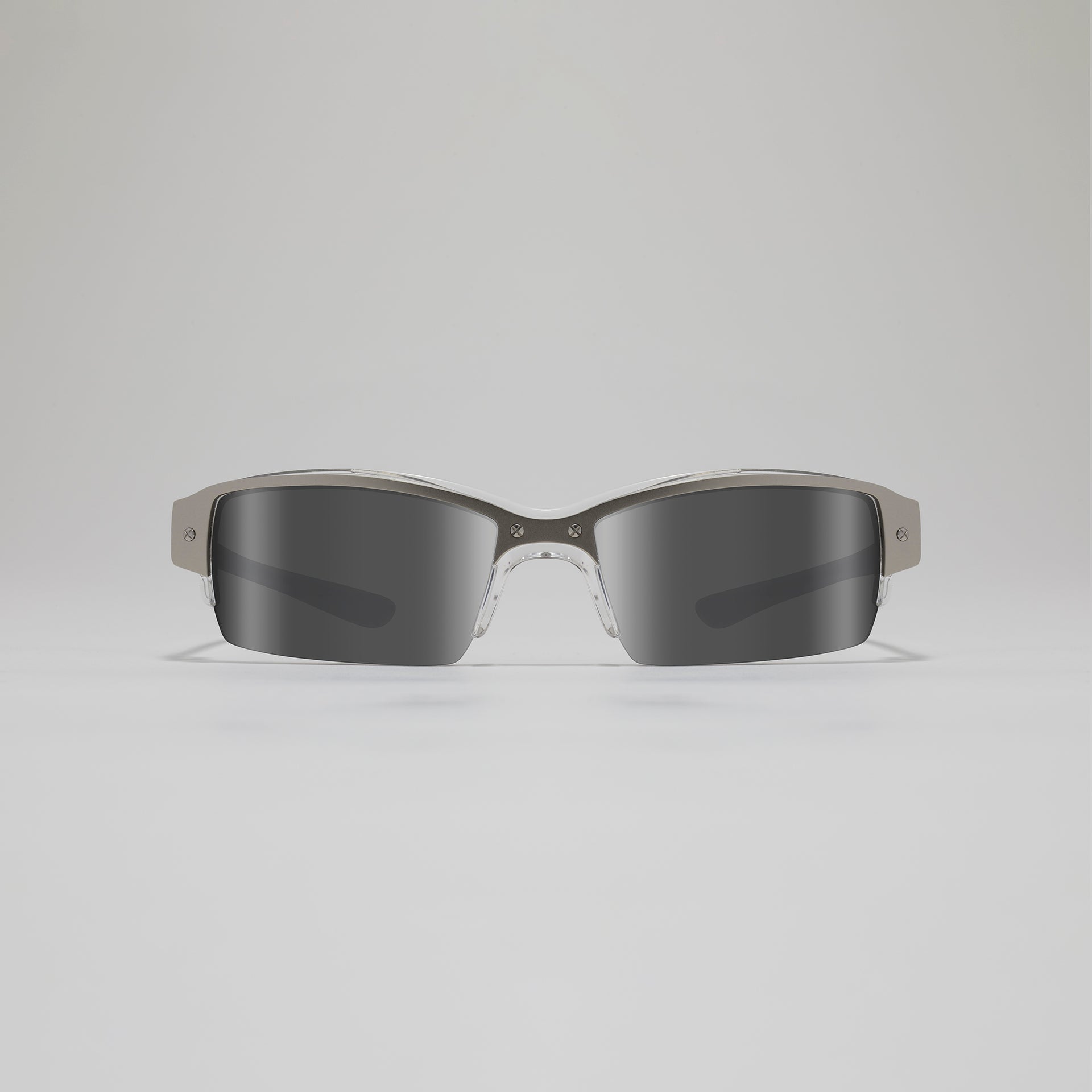 Sunglasses with a clear frame and dark lenses on a light gray background