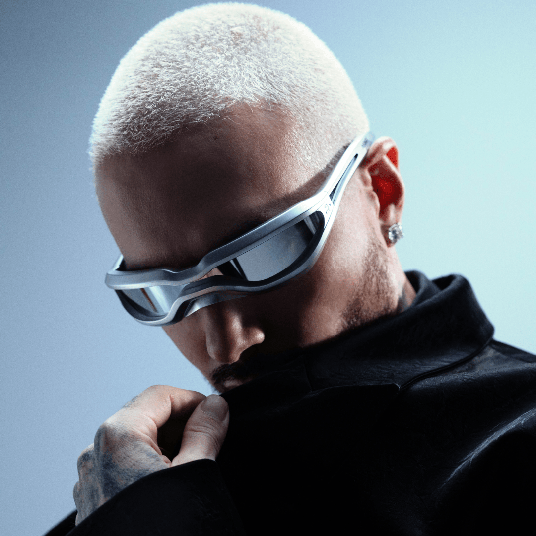 Person wearing futuristic sunglasses with a gray background