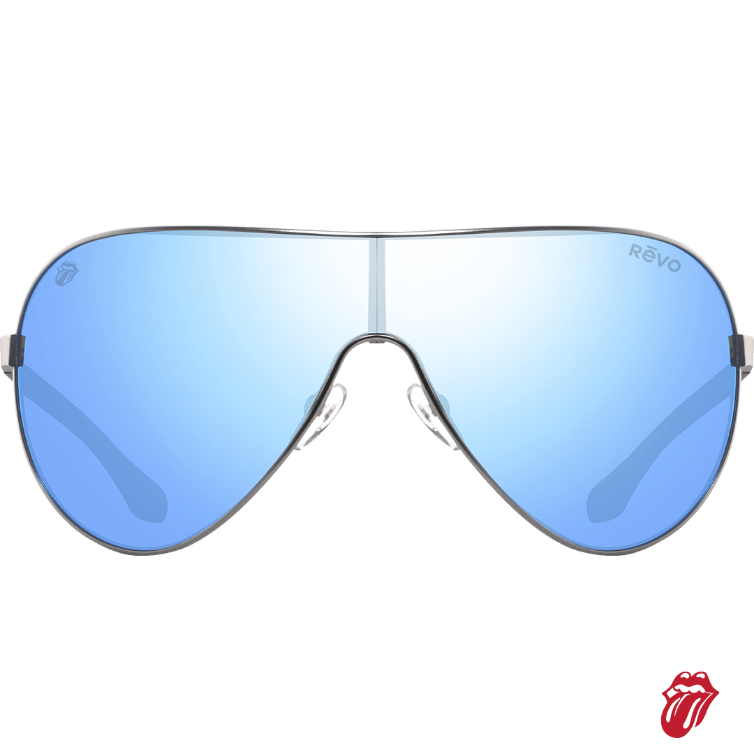 A pair of shield-style aviator sunglasses with a silver metal frame and mirrored blue lenses. The brand name 'REVO' is printed on the top right corner of the lens, and a red and white Rolling Stones logo is visible in the bottom right corner of the image.