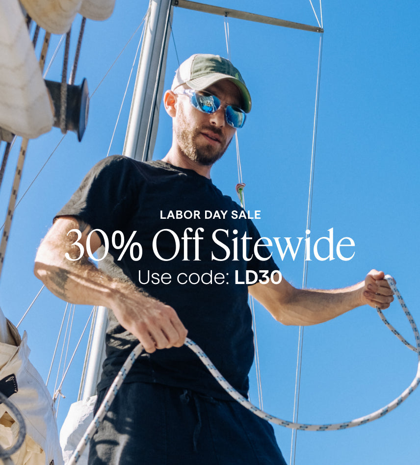 Man on a sailboat with Labor Day sale text overlay