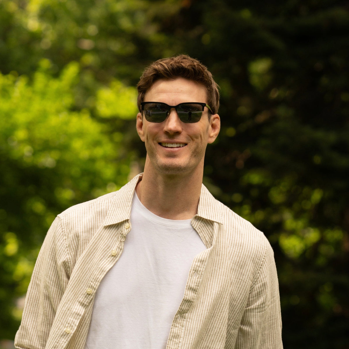 Portrait of a man wearing Andy modern clubmaster sunglasses with biodegradable acetate frames and dark lenses.