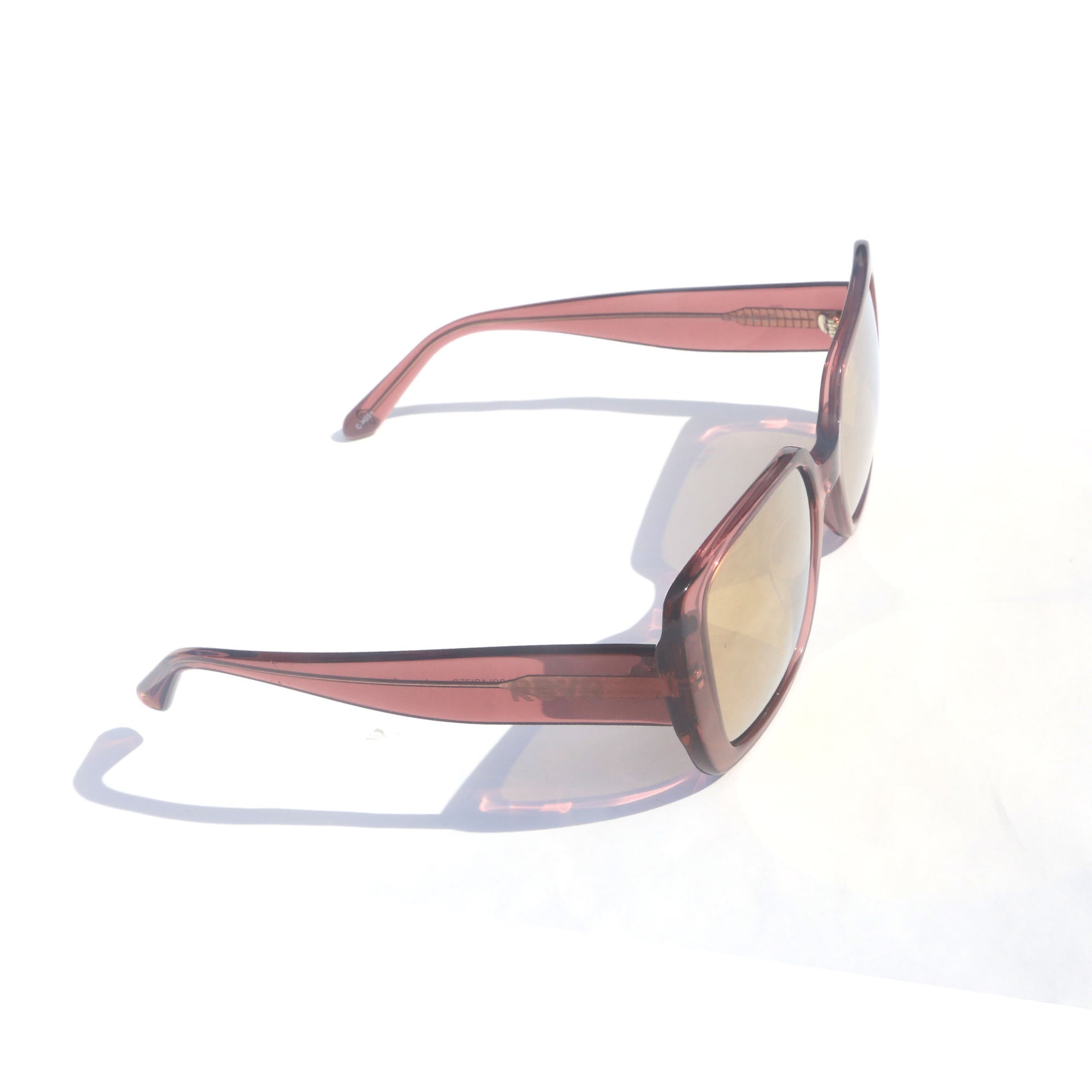 Sunglasses with pink frame and reflective lenses on a white background