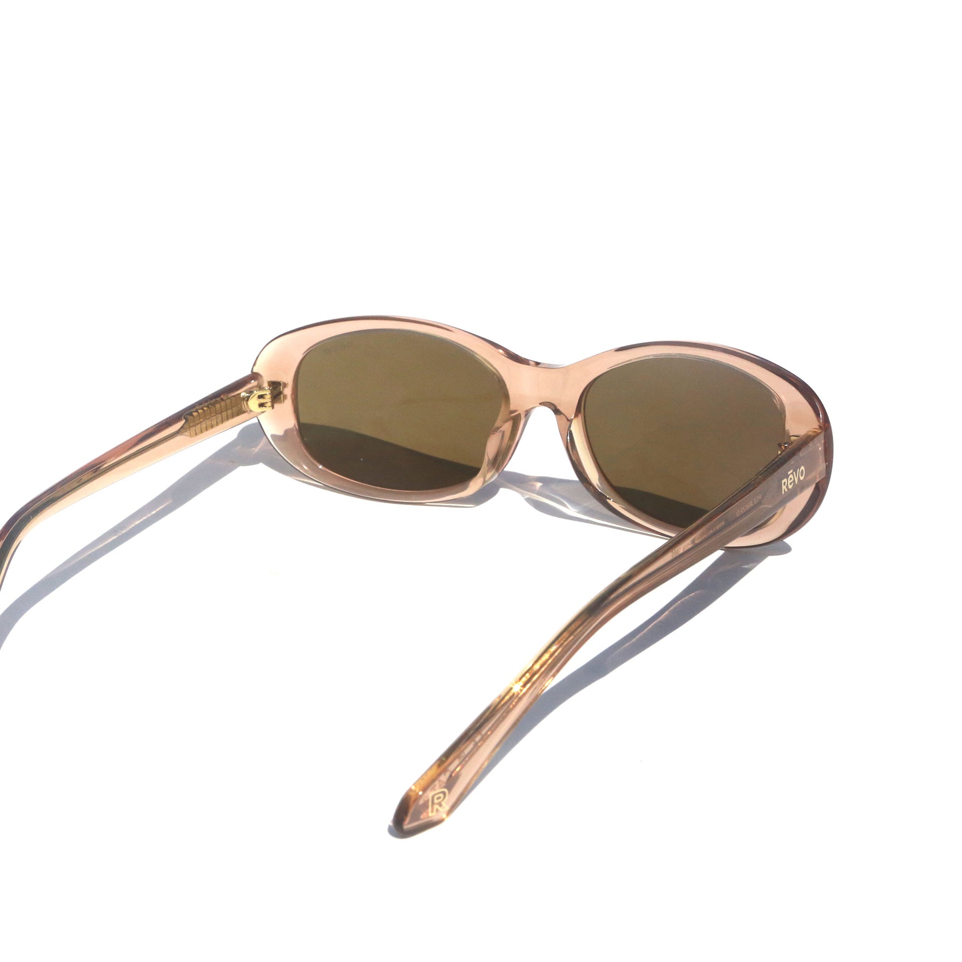 Sunglasses with a rose gold frame and dark lenses on a white background