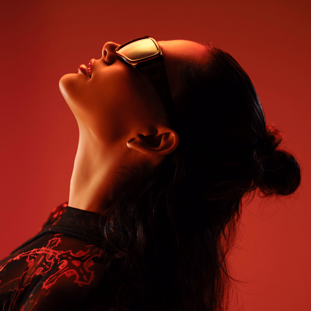 Person wearing futuristic goggles against a red background